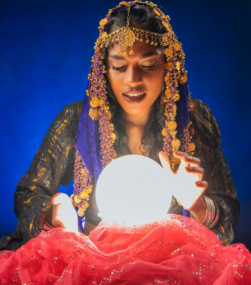 A fortune teller South Asian woman holds a glowing crystal ball