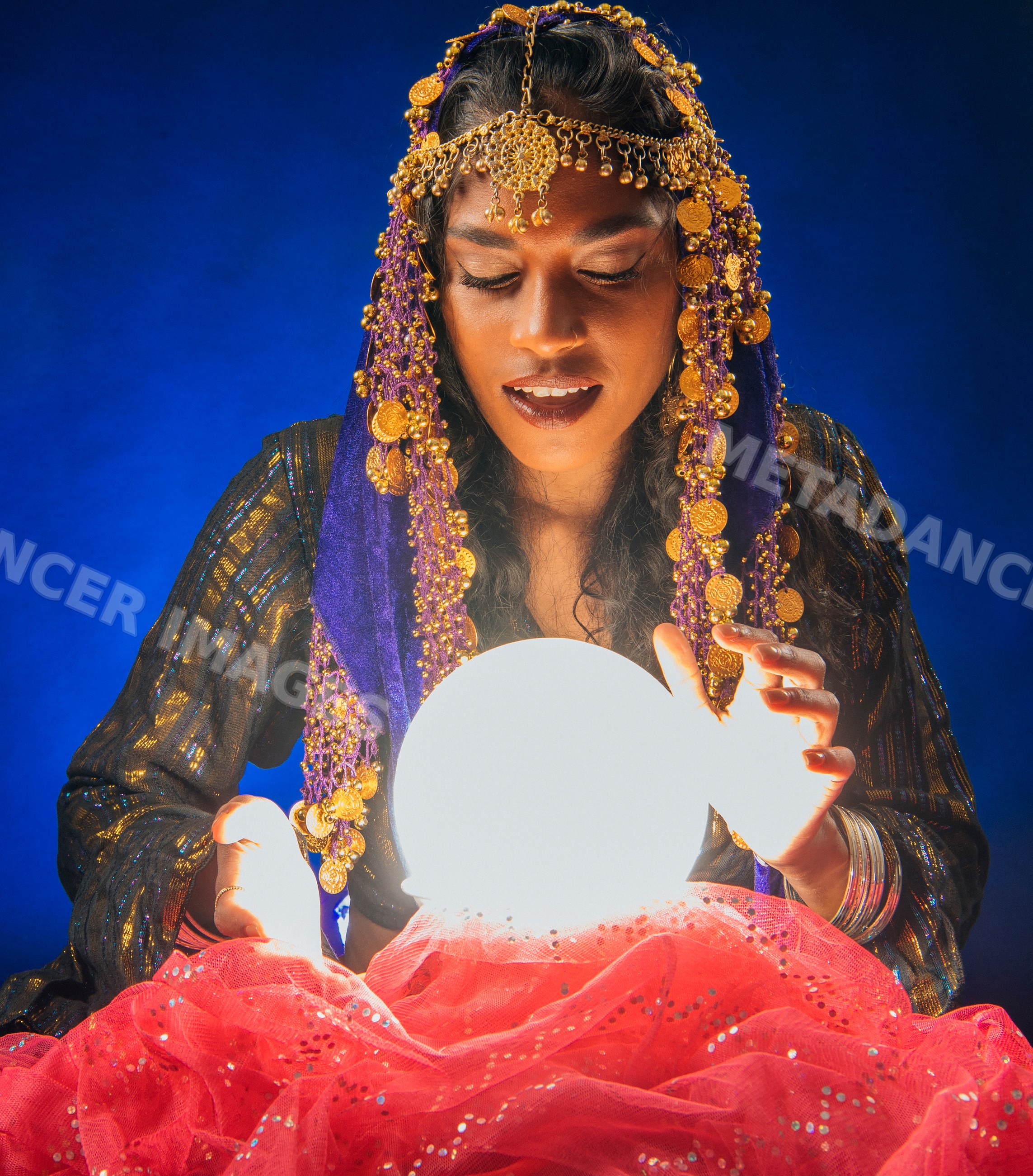 A fortune teller South Asian woman holds a glowing crystal ball