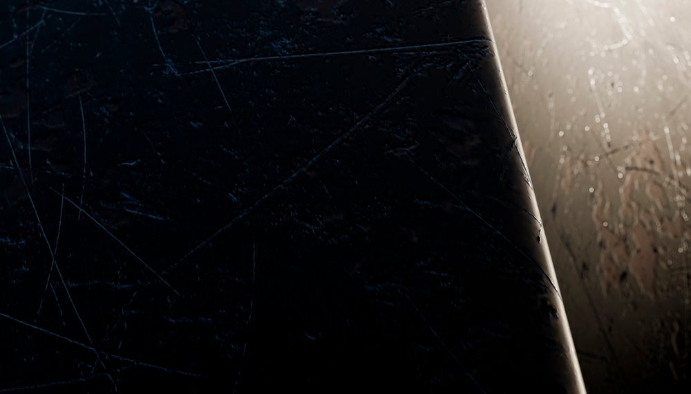 Close-up of scratched and worn dark metal surface under dim lighting