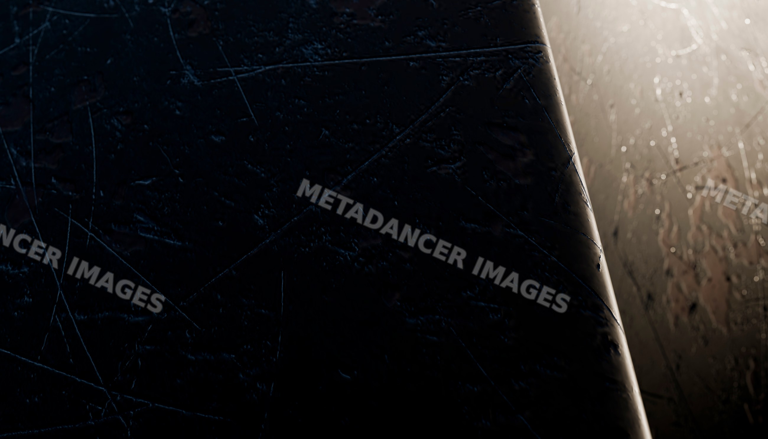 Close-up of scratched and worn dark metal surface under dim lighting