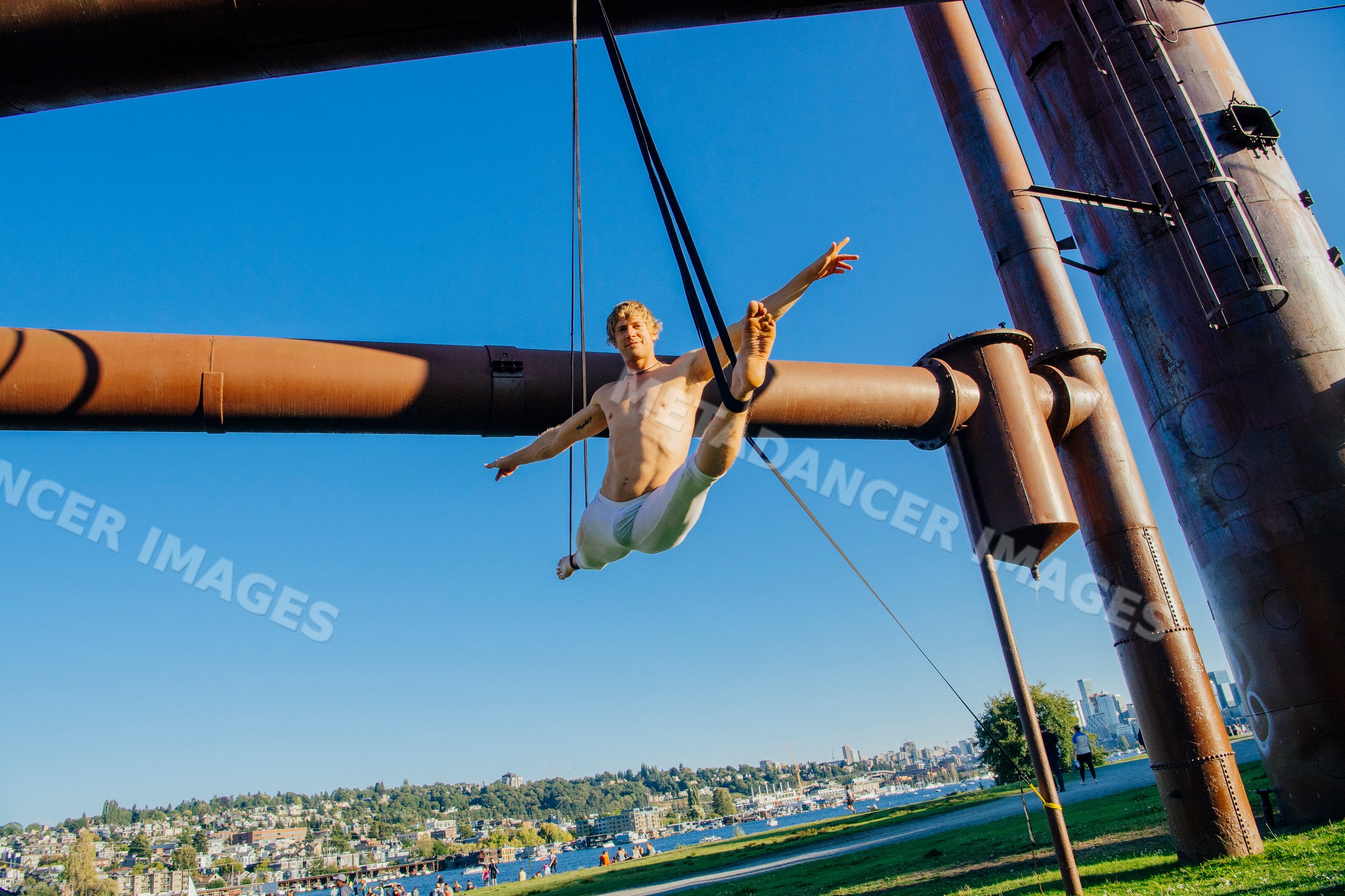 Man performing aerial silk exercise outdoors in Seattle park