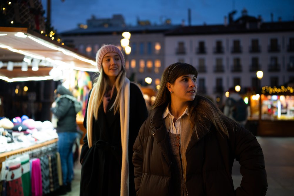 White women shopping at christmas market in Madrid evening