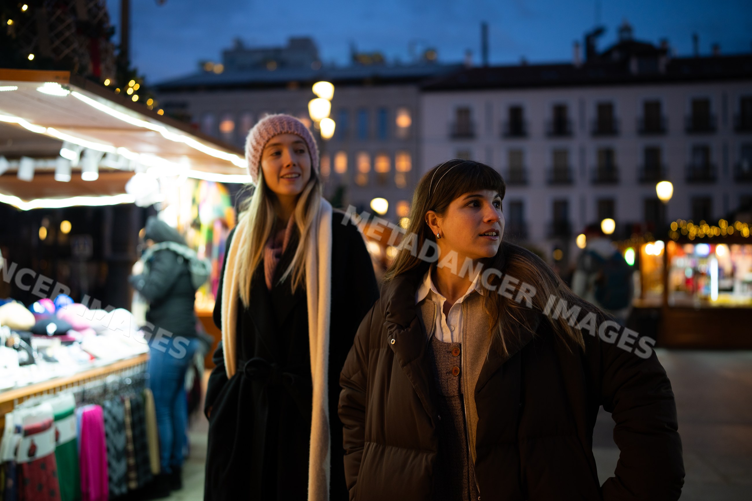White women shopping at christmas market in Madrid evening