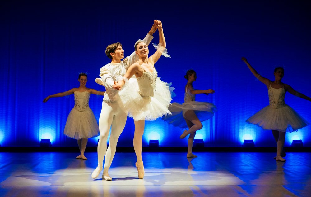 Ballet dancers perform a classical routine on stage during a ballet