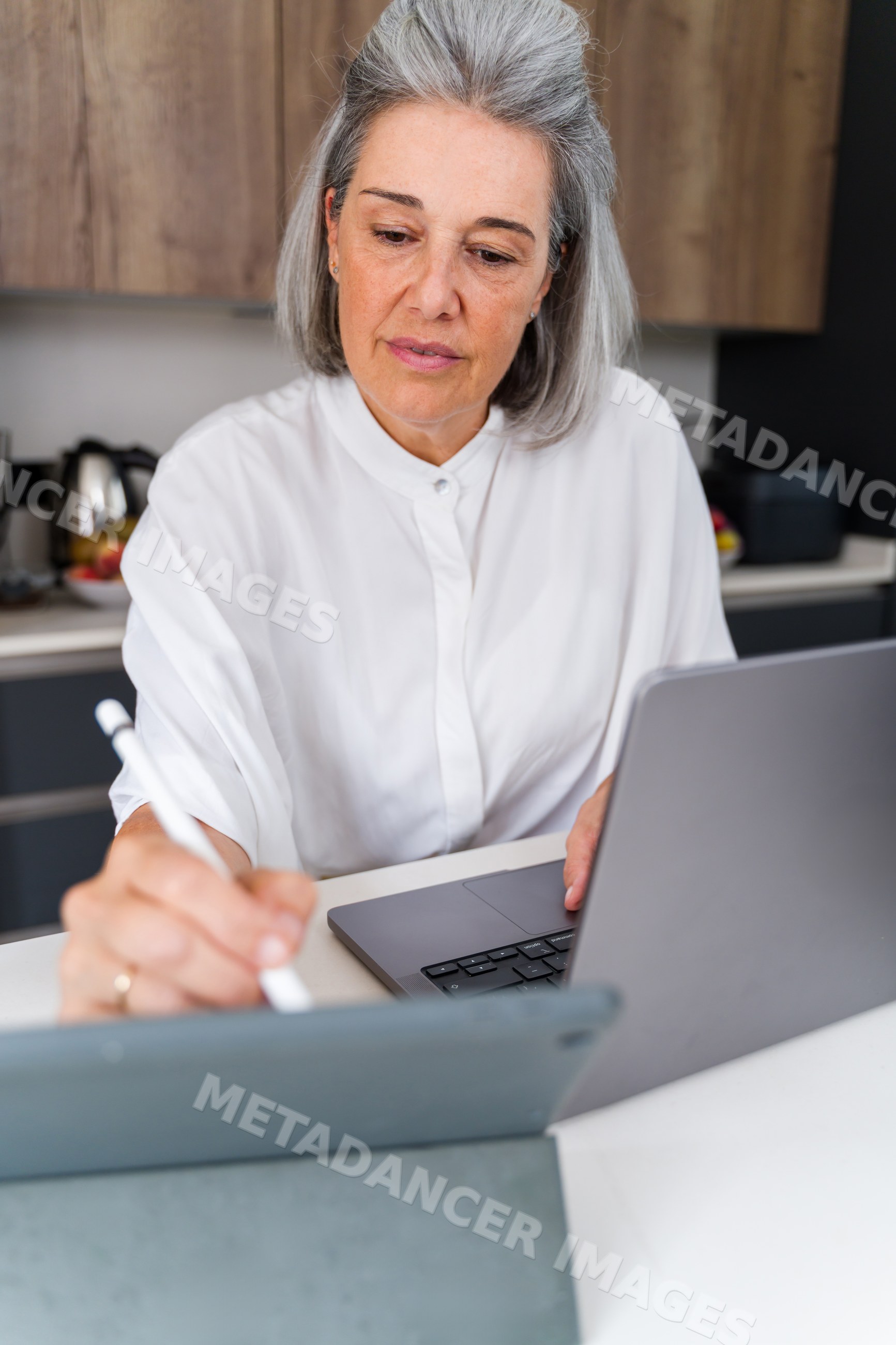 White Woman working with digital pen and laptop at home in Spain