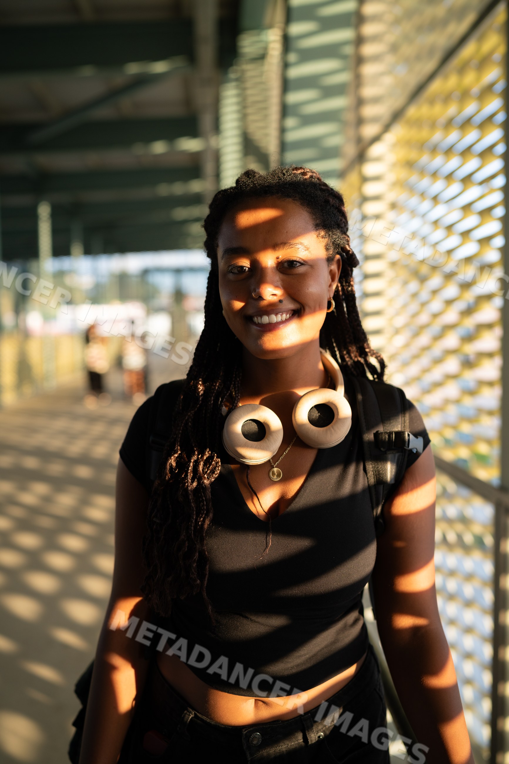 A young African American woman smiles wearing headphones