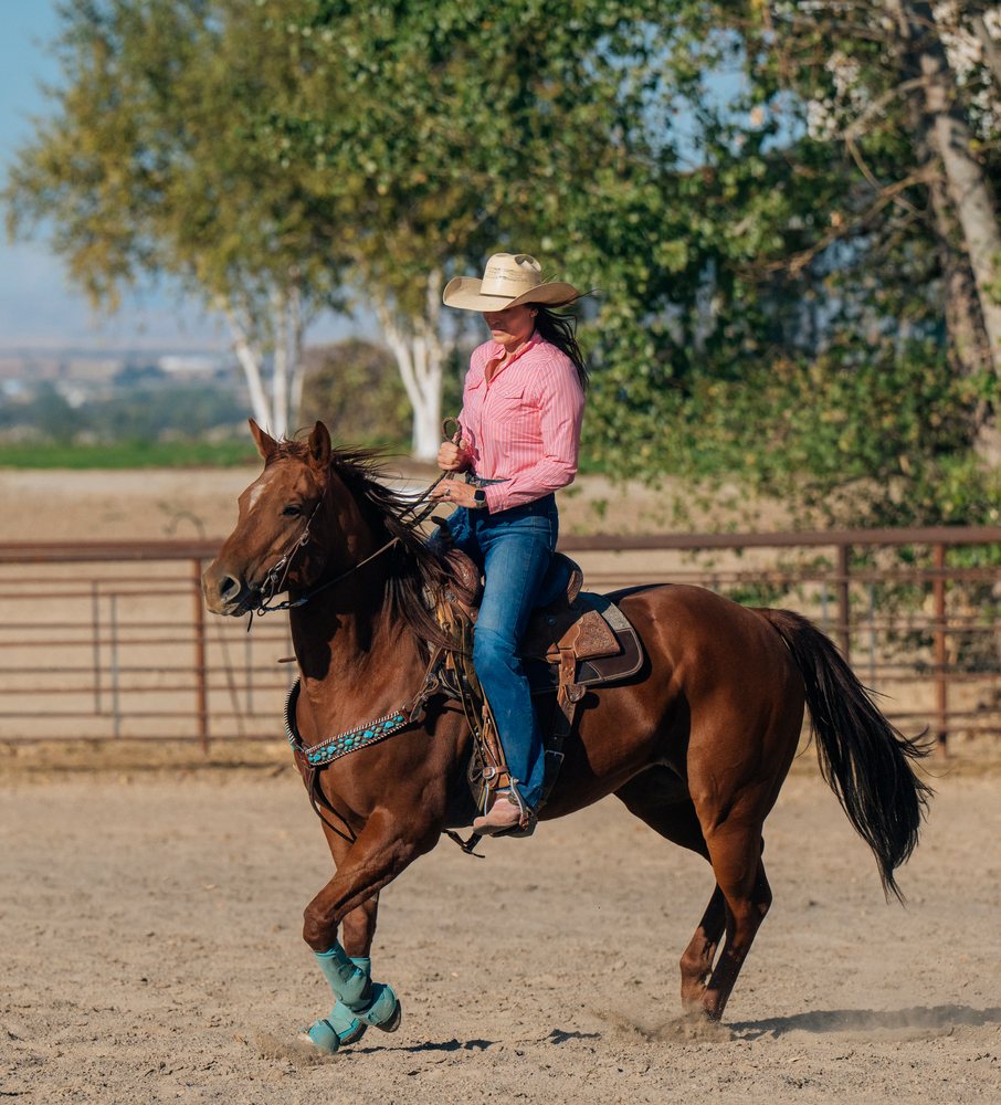 White woman riding brown horse
