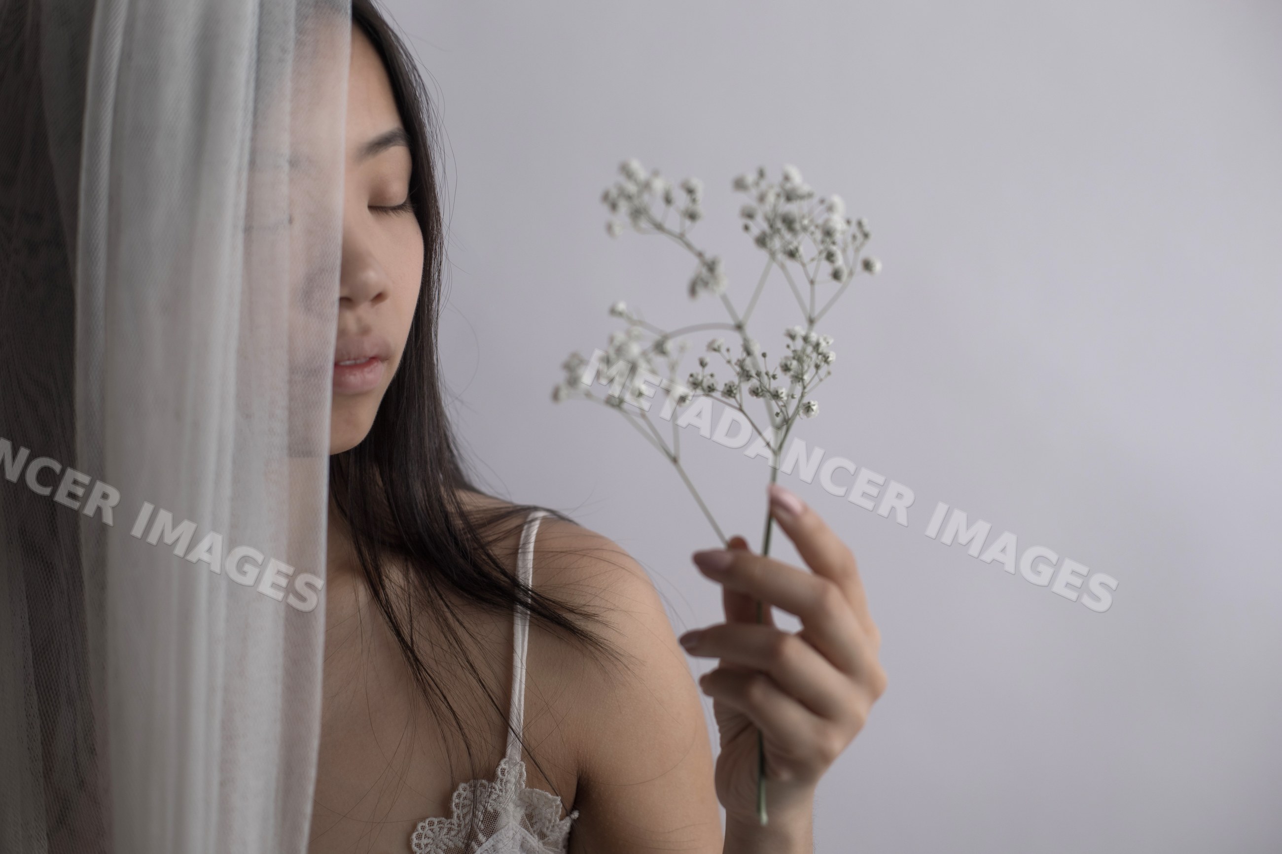 Portrait of Southeast Asian woman holding baby's breath flower