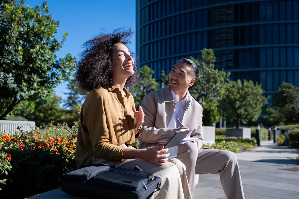 Two professionals having an outdoor business conversation with tablet
