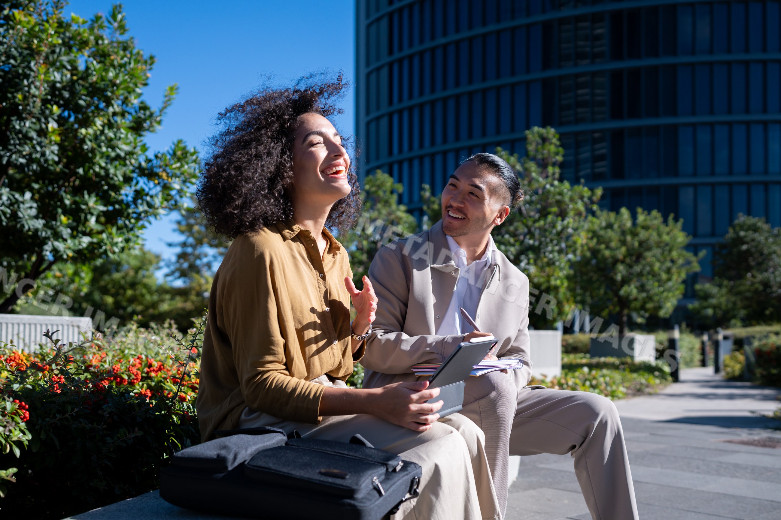 Two professionals having an outdoor business conversation with tablet