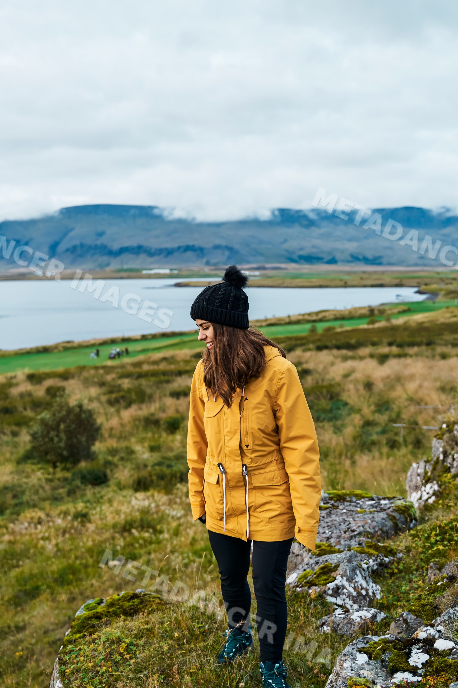 A white woman hikes along rocky terrain