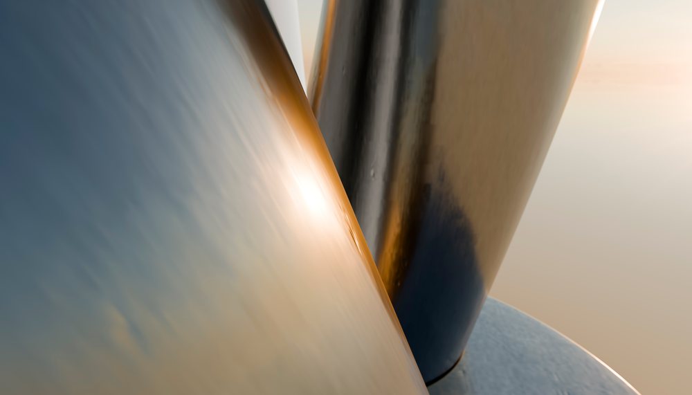 Close-up of smooth reflective curved metal surfaces with warm light