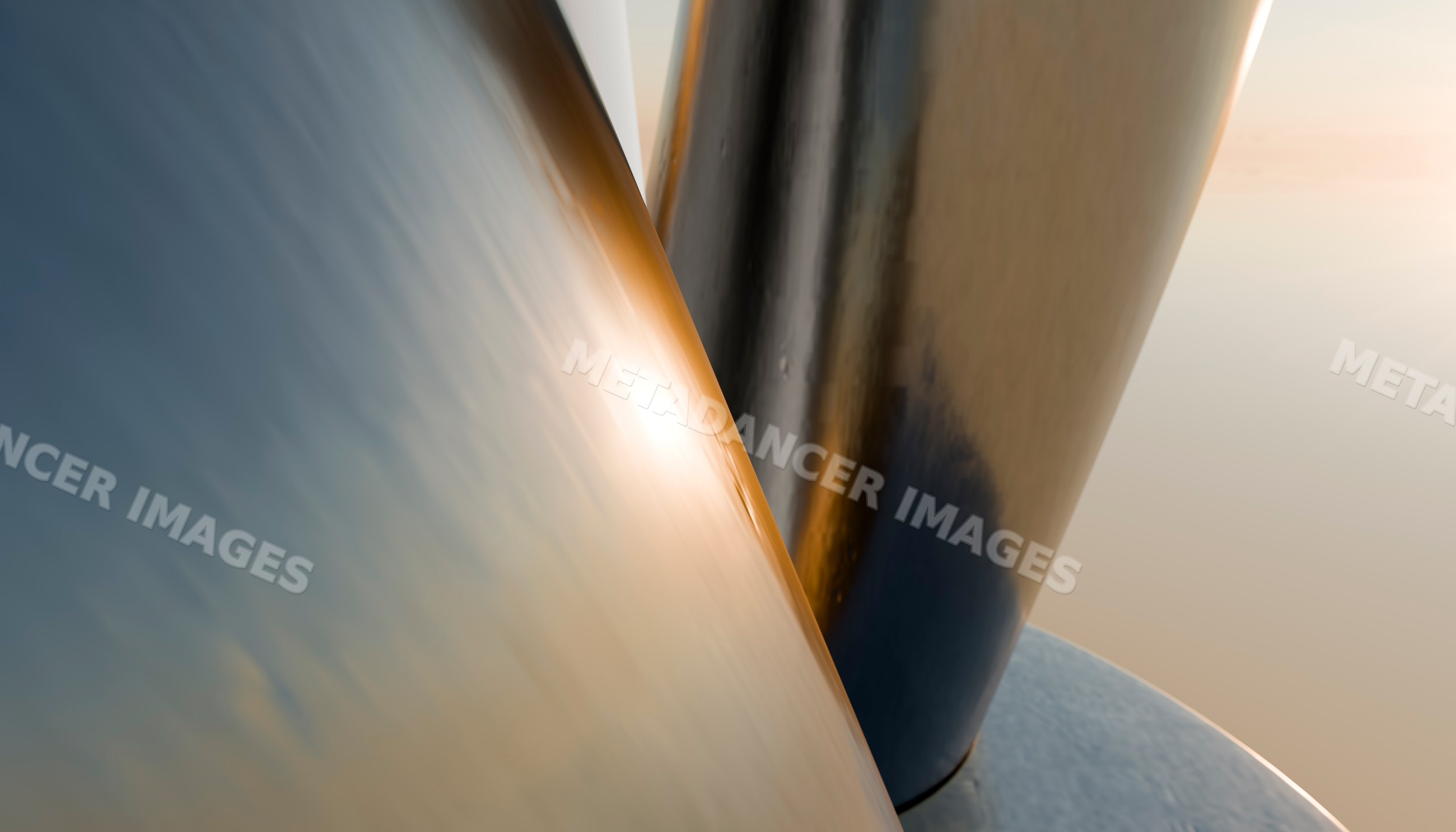 Close-up of smooth reflective curved metal surfaces with warm light