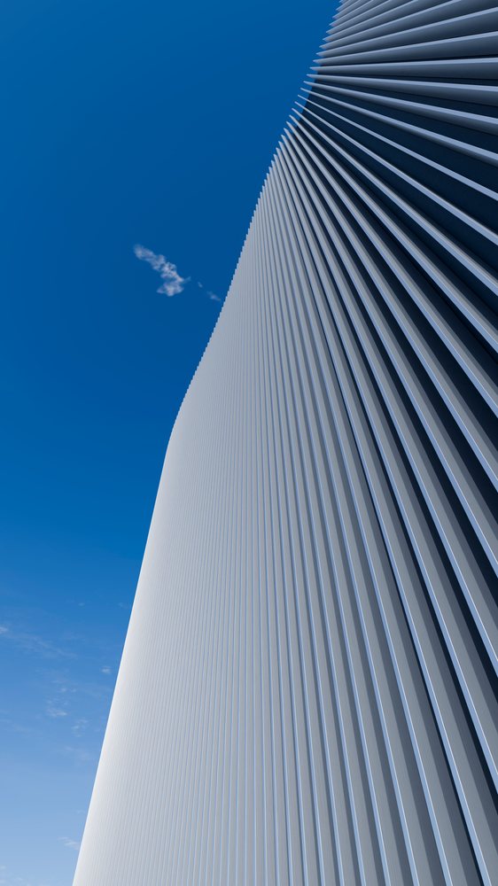 Modern building facade with vertical metal siding and clear blue sky