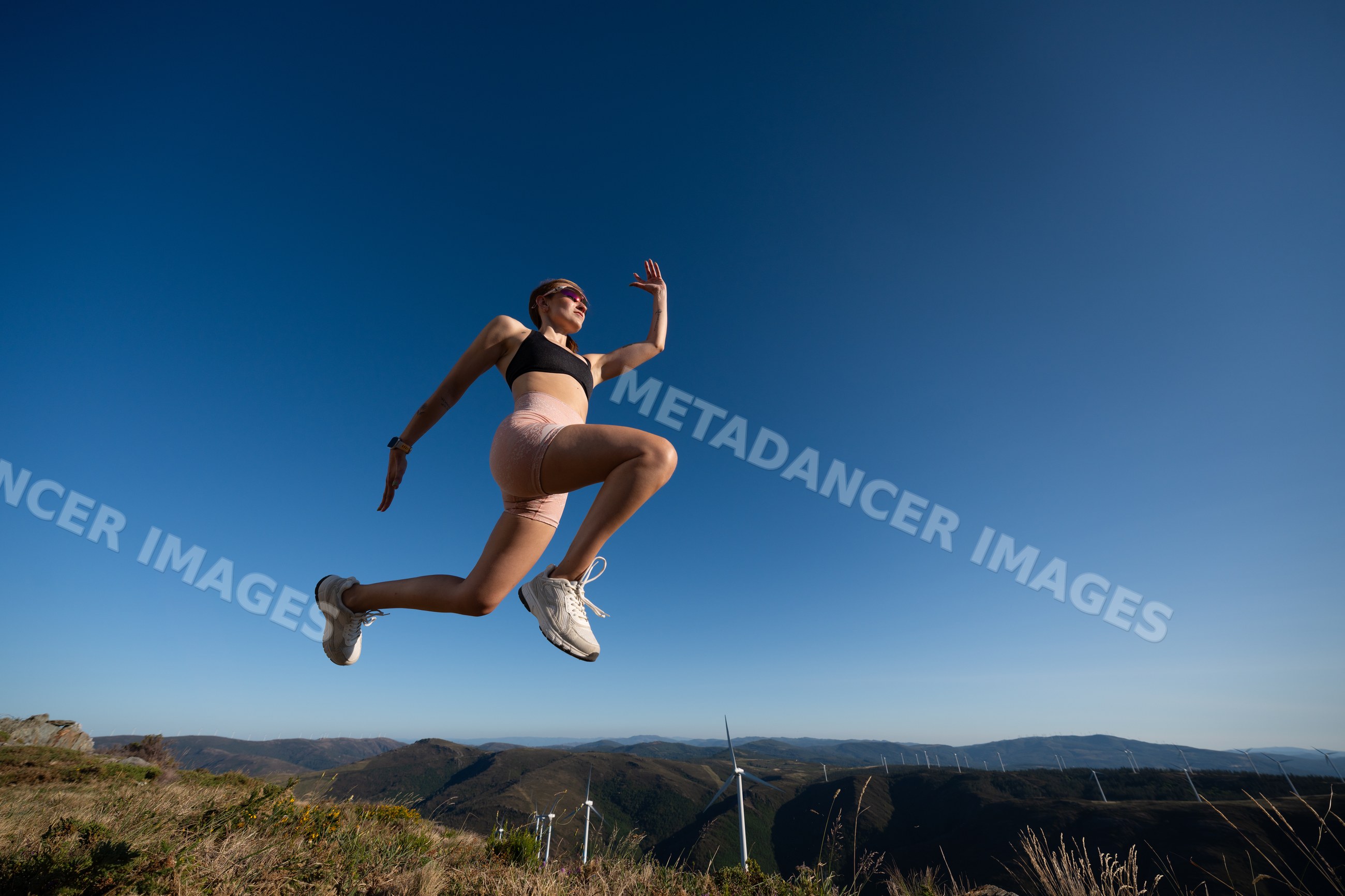A white woman jumps energetically during an outdoor workout in Galicia