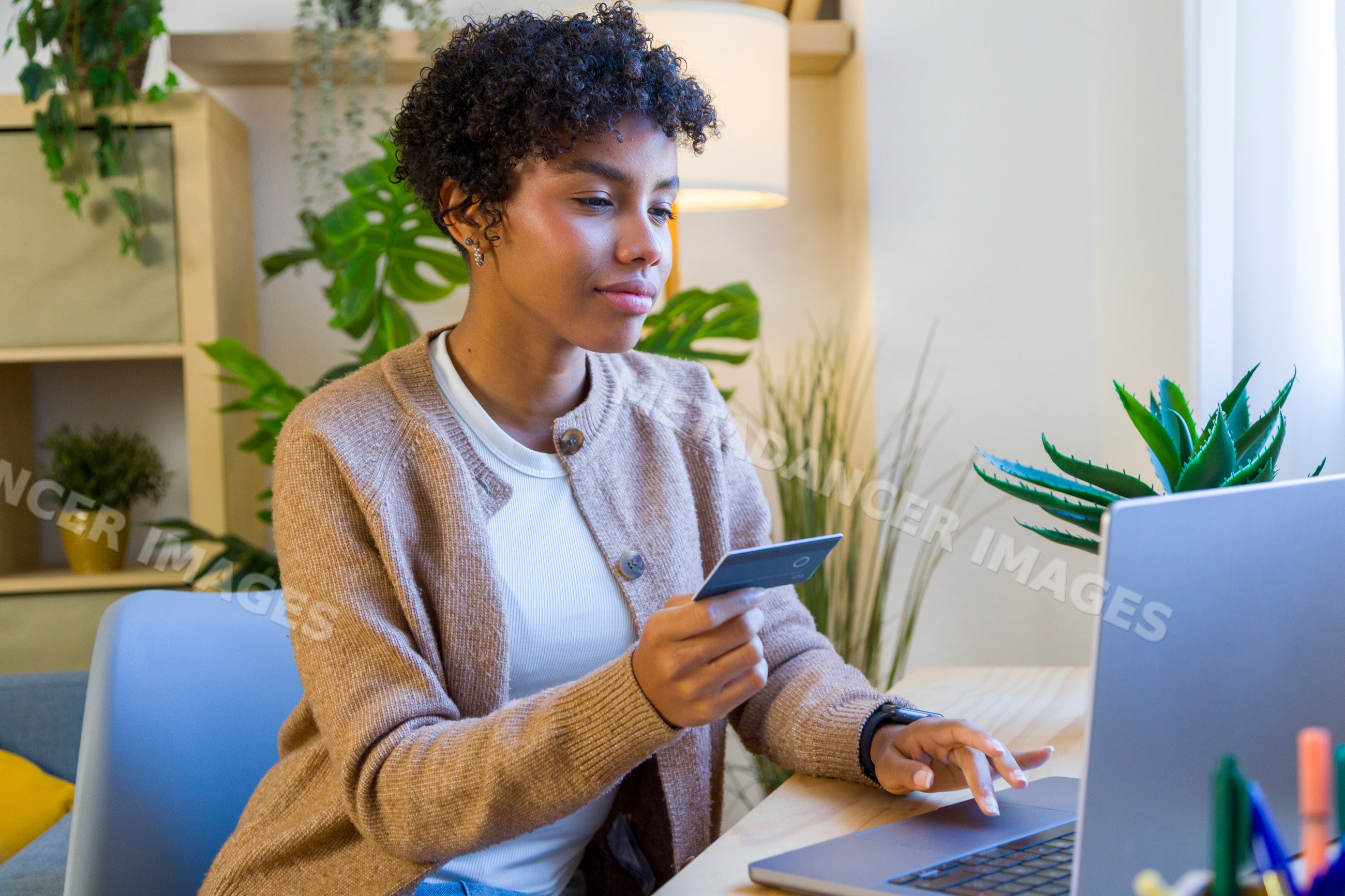 African American woman using credit card and laptop