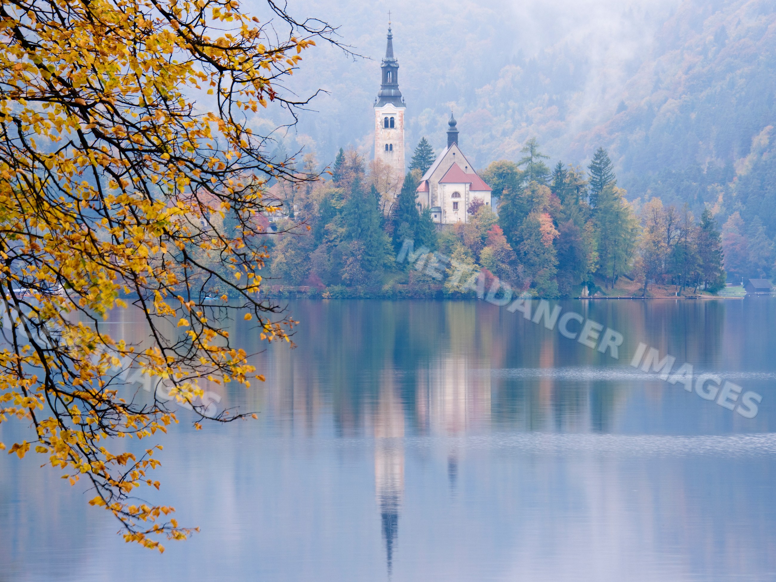 Church of assumption on an island reflected in autumn water