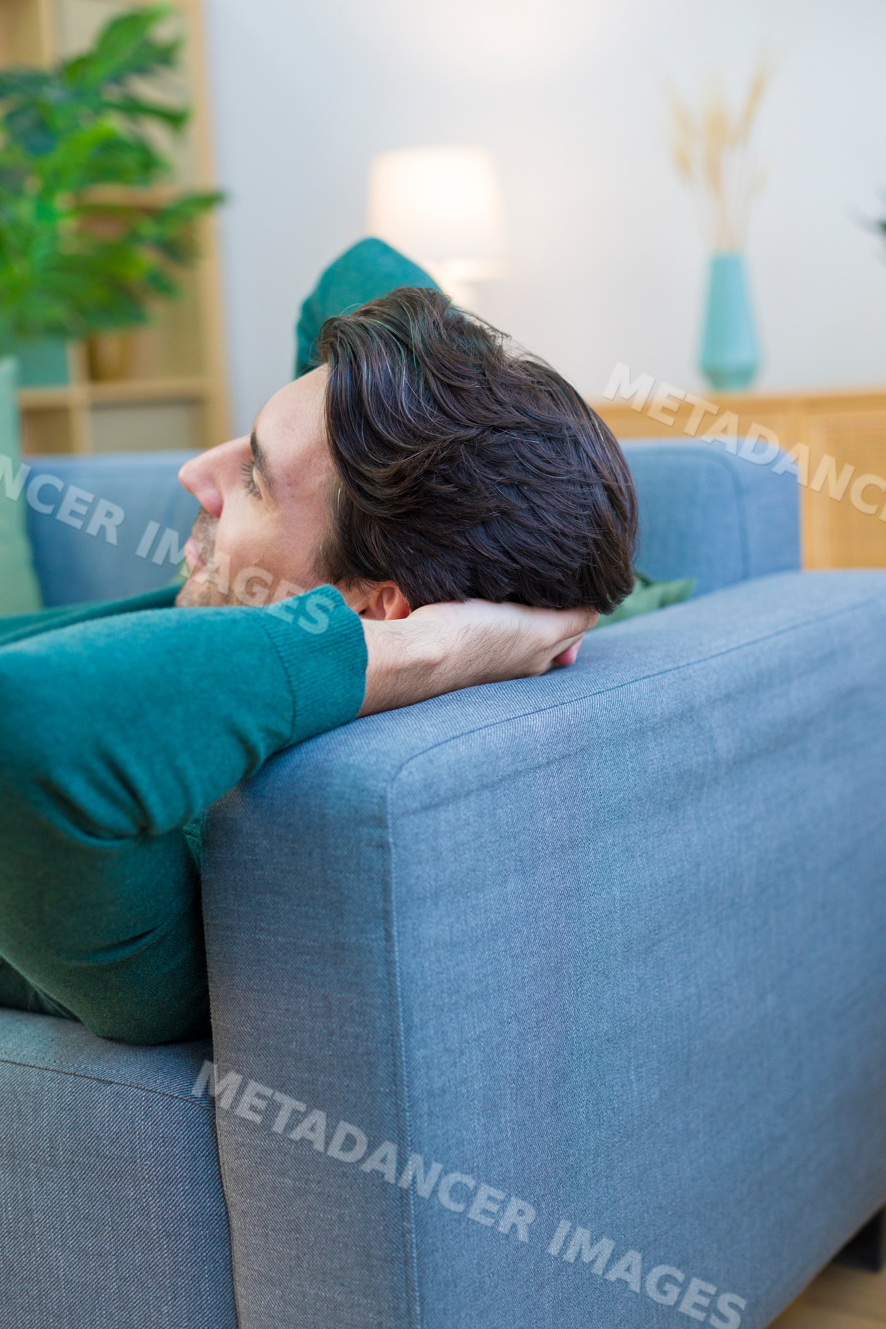 White man resting on a couch in a modern living room