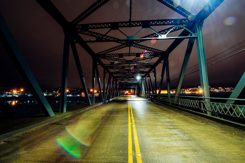 Steel bridge at night illuminated by city lights in Tacoma washington