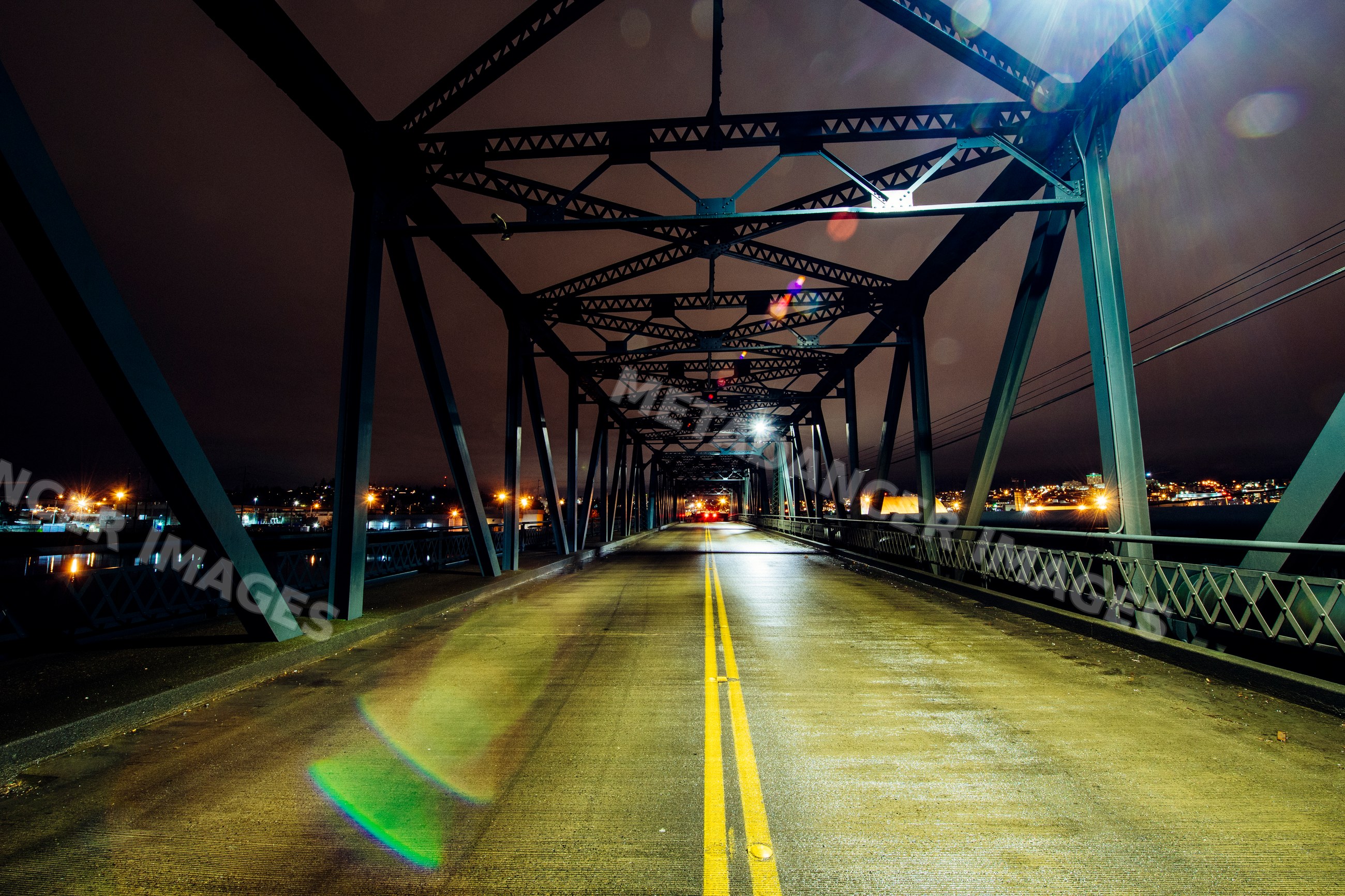 Steel bridge at night illuminated by city lights in Tacoma washington
