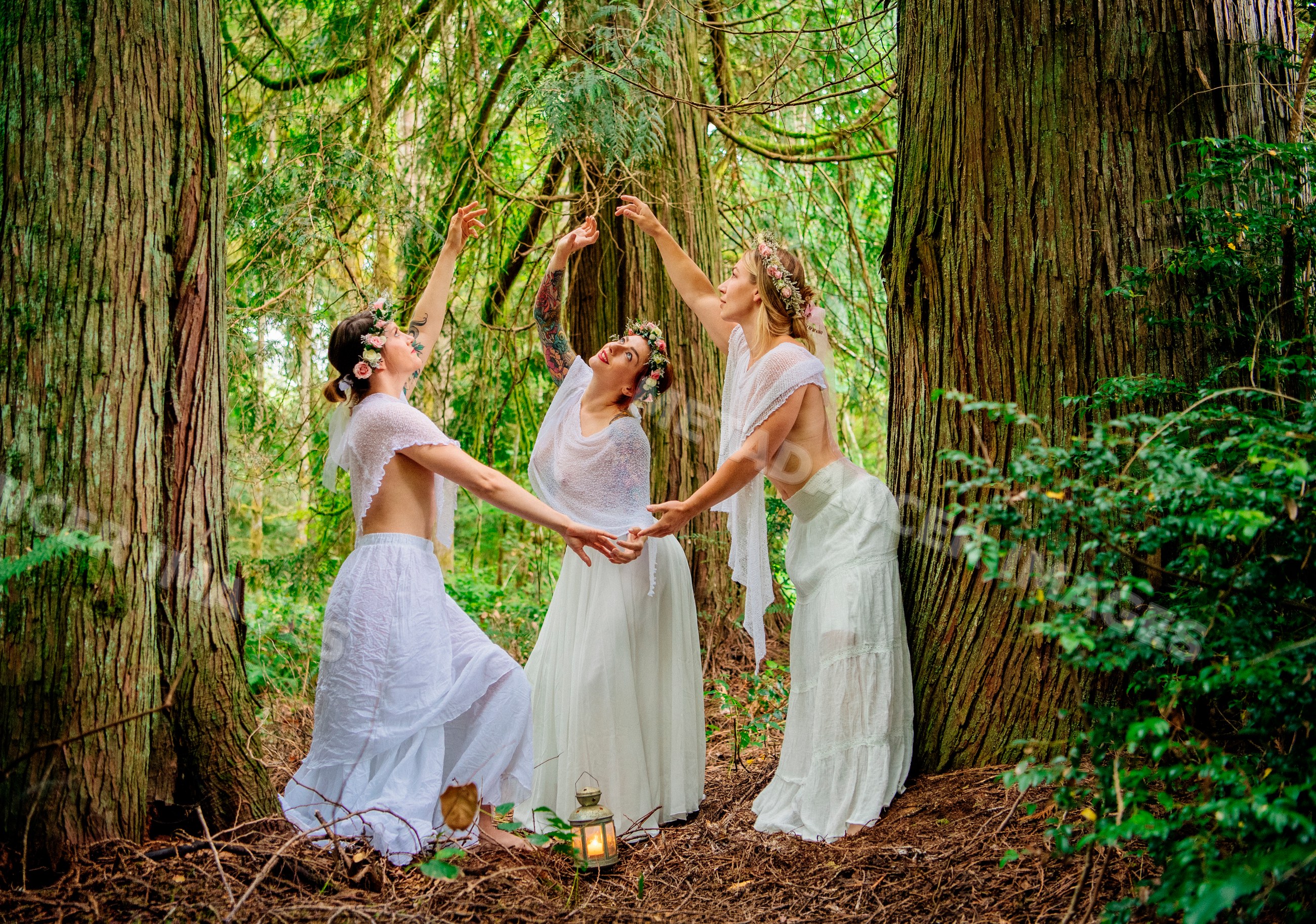 White women dancing with flower crowns in forest among tall trees