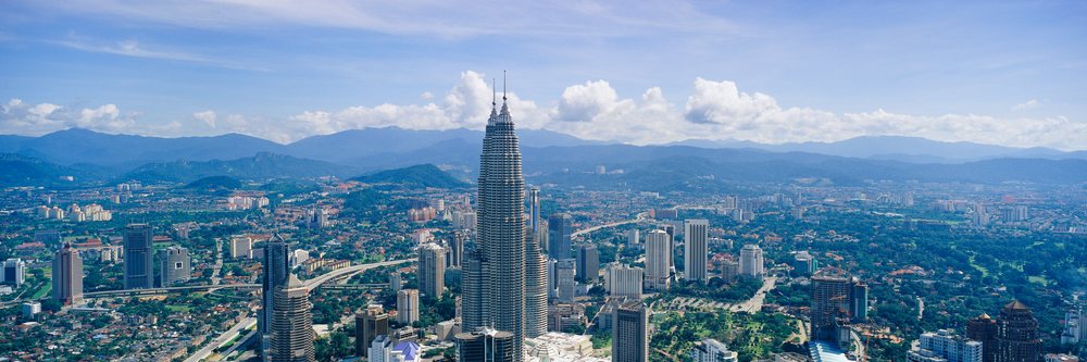 Kuala lumpur cityscape with petronas towers and mountains
