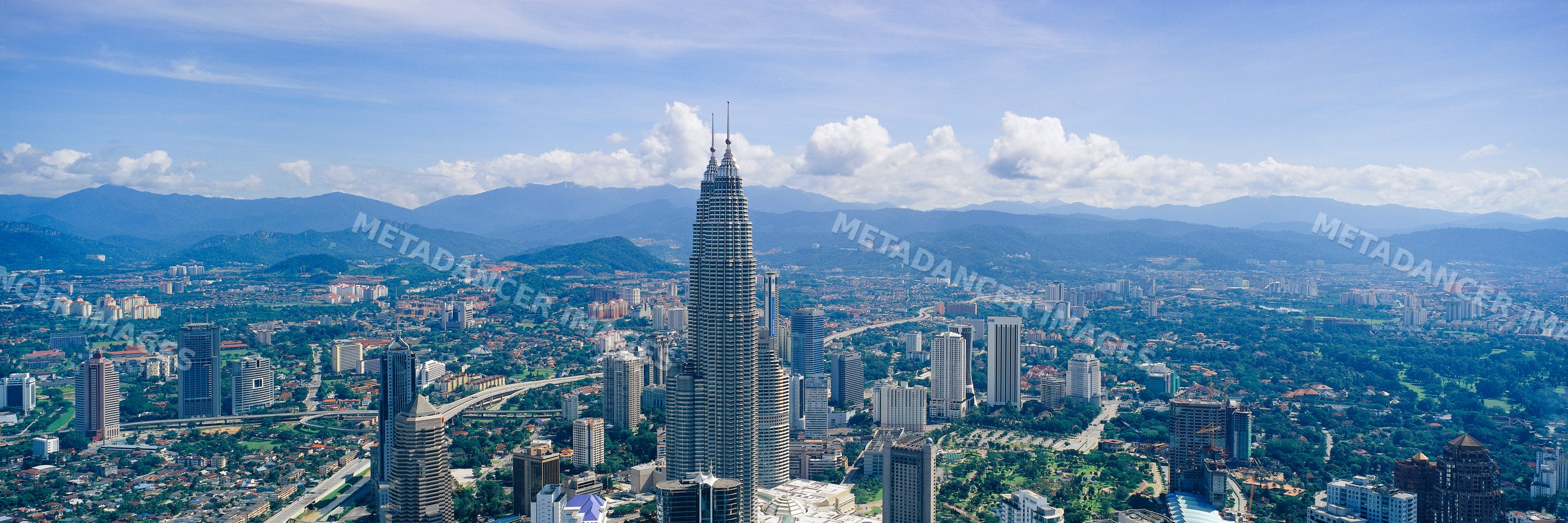 Kuala lumpur cityscape with petronas towers and mountains