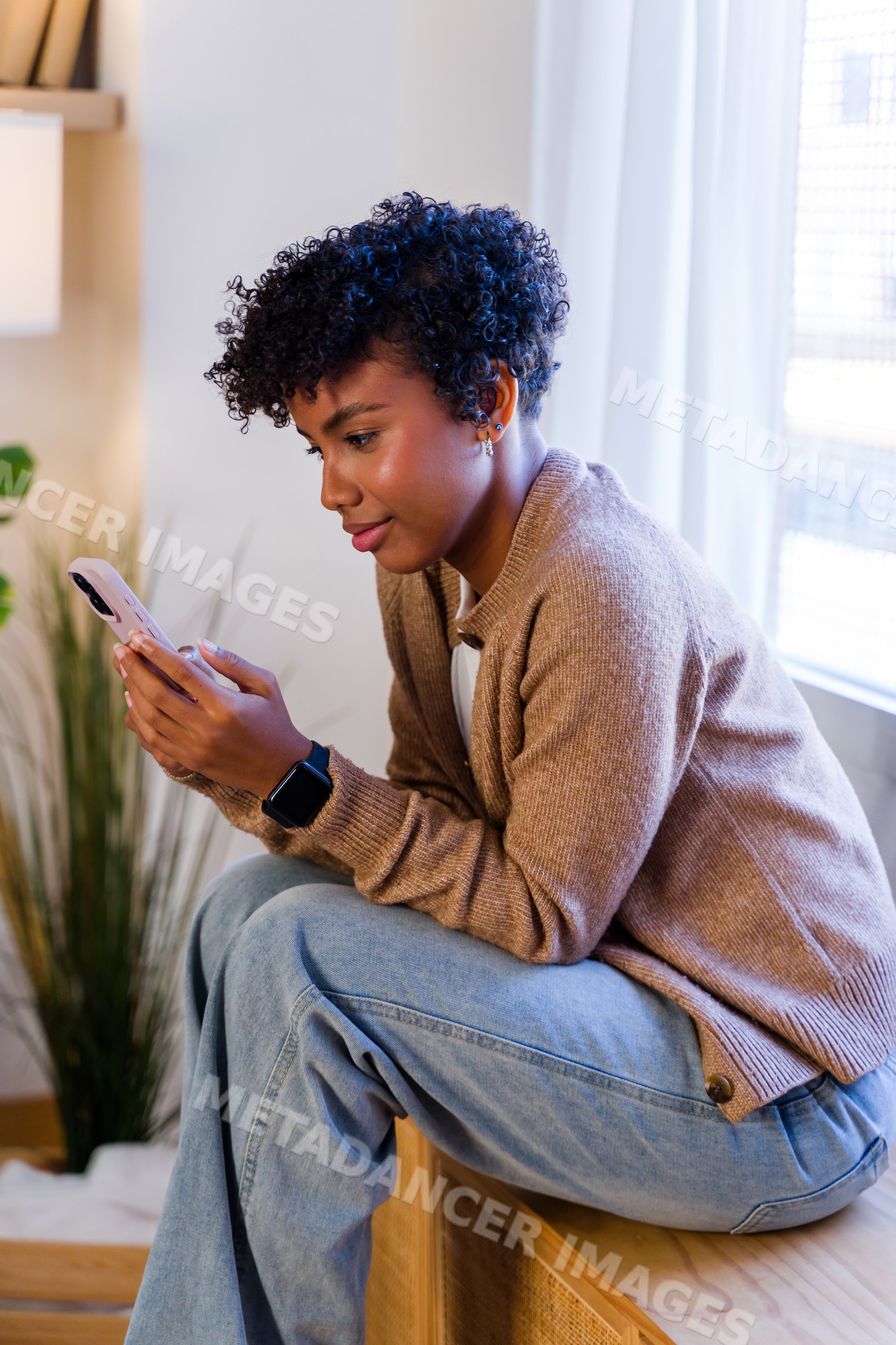 African American woman using smartphone indoors wearing casual clothes