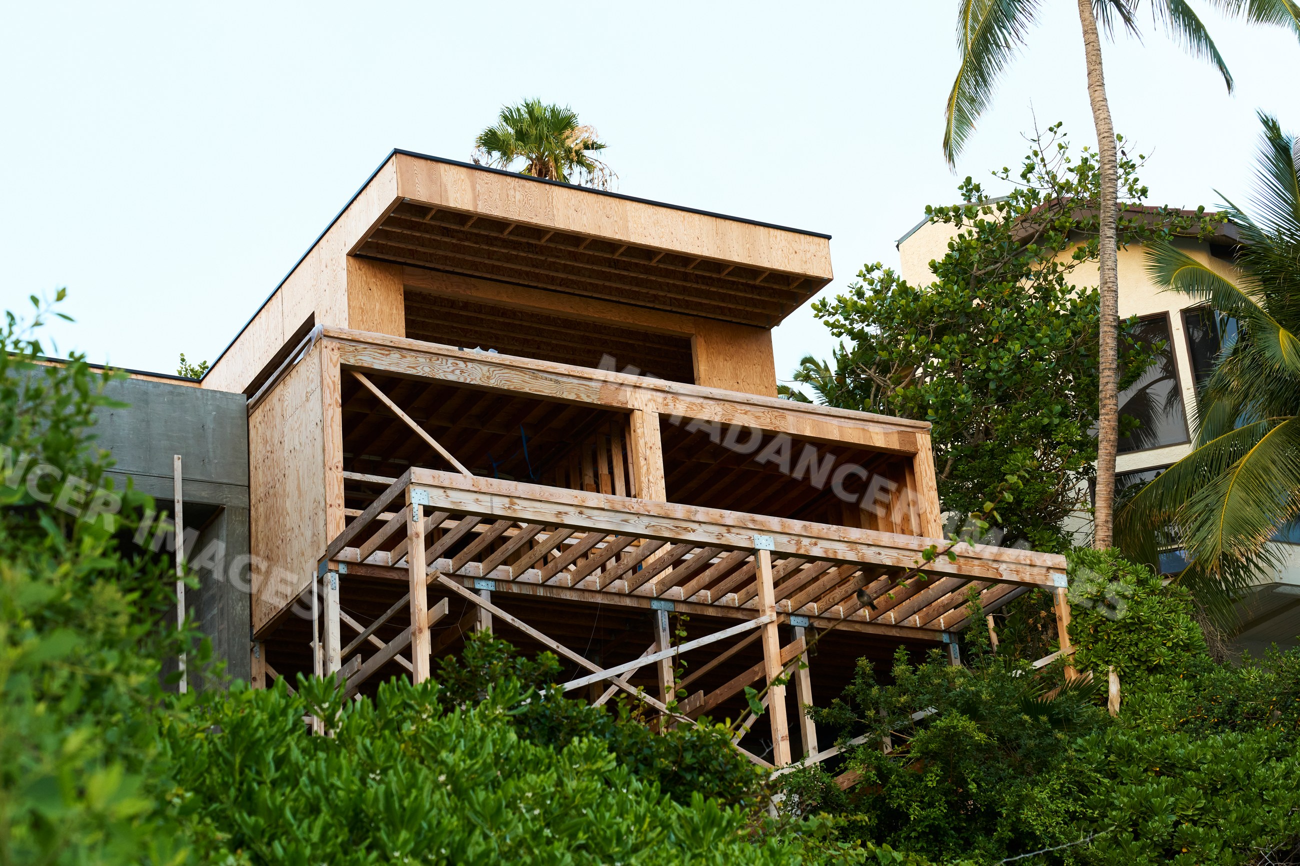 House under construction with wood framing in tropical Oahu setting