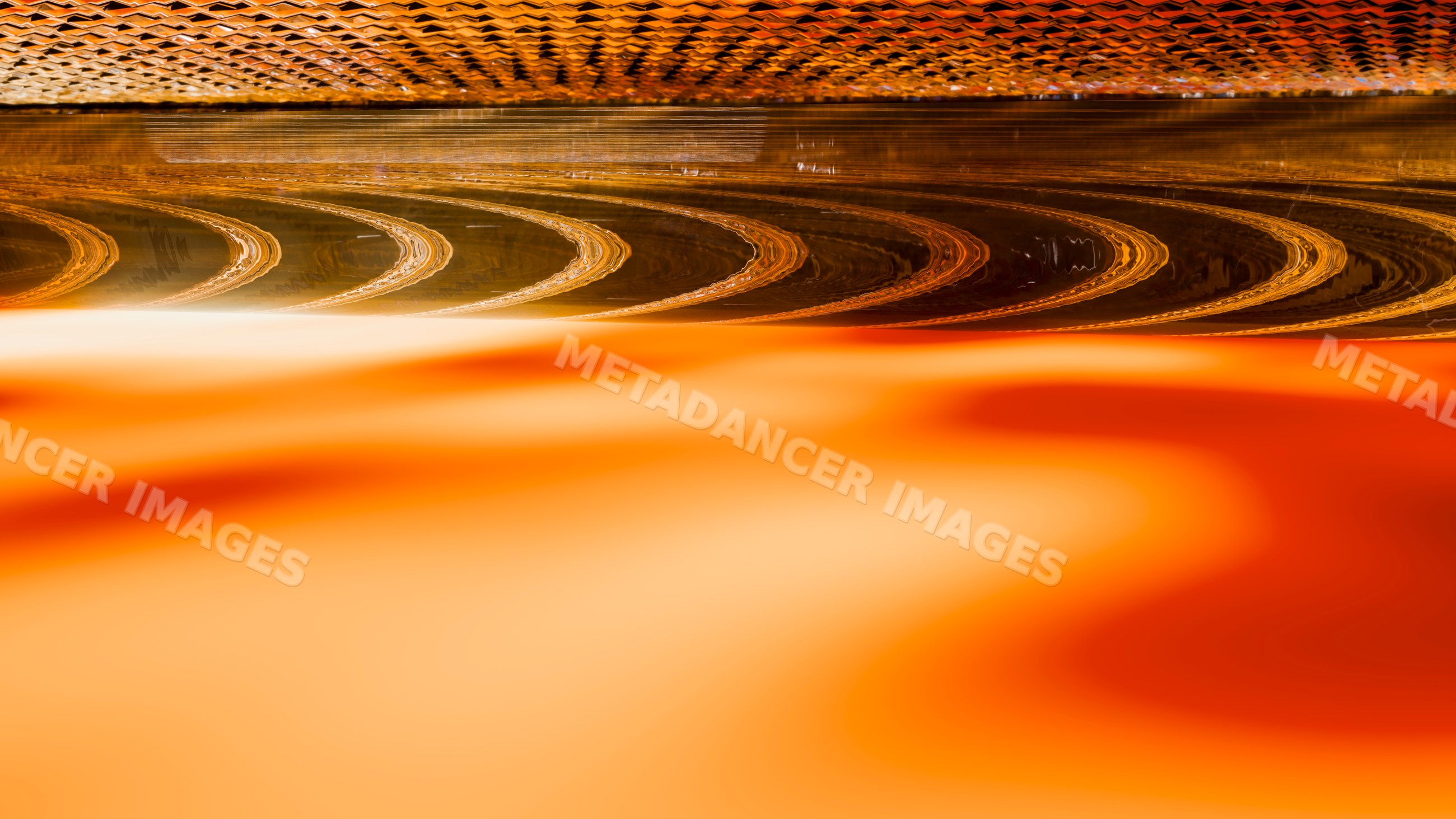 Abstract orange liquid with reflective wavy surface pattern