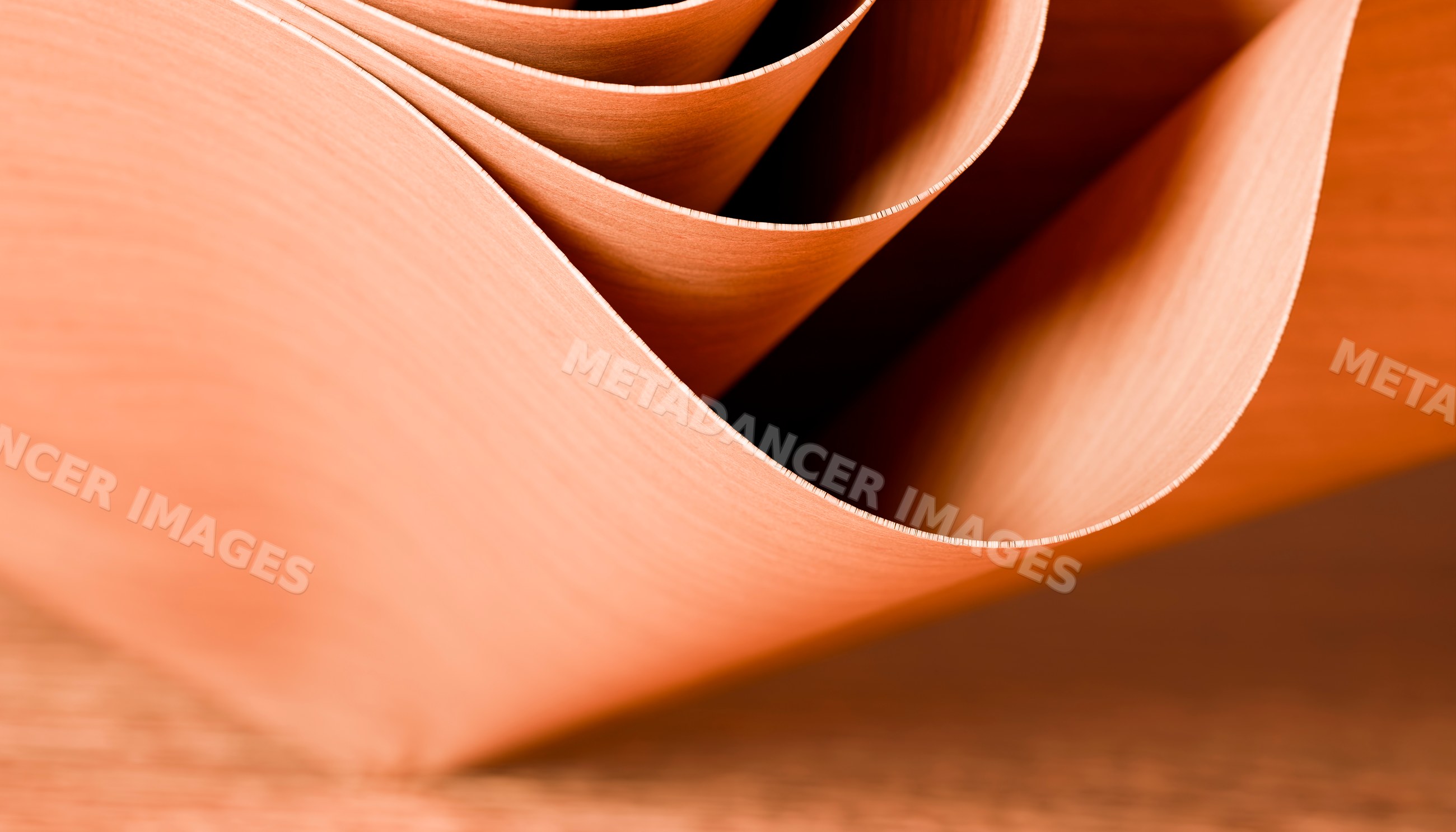 Thin curved wood veneer sheets showing natural texture and grain
