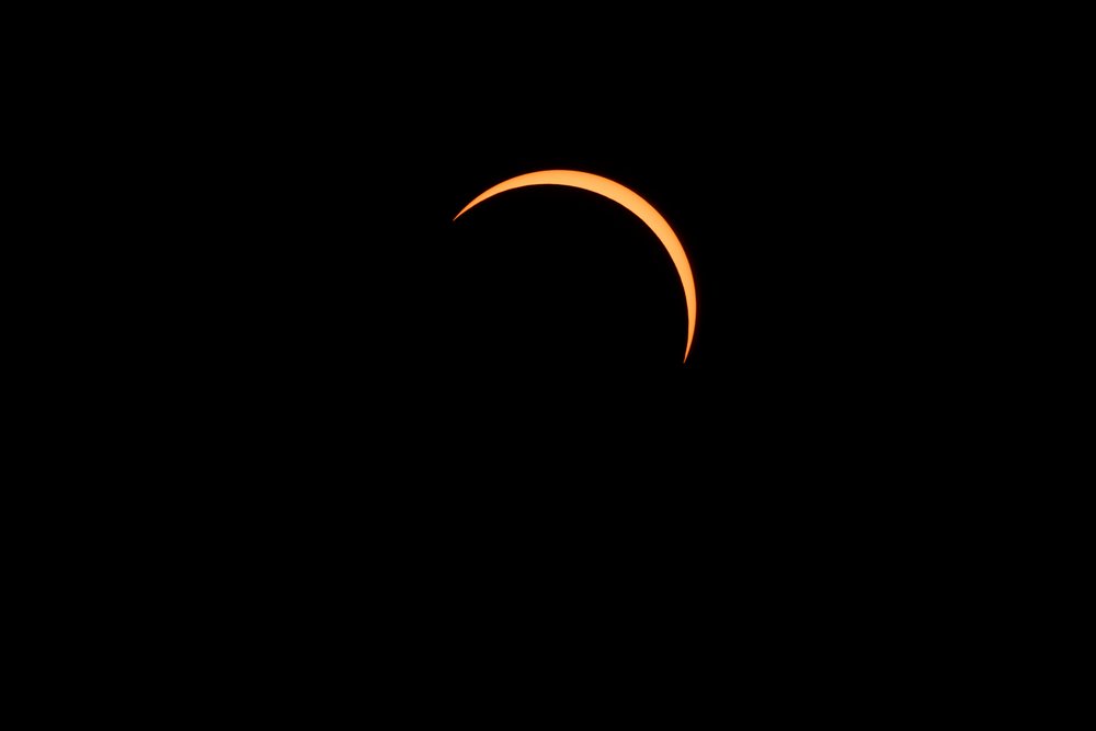 Solar eclipse showing crescent moon silhouetted against the sun