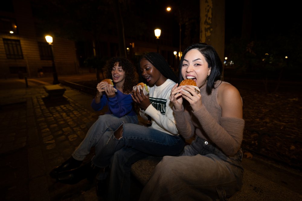 Hispanic, white and Black women enjoying burgers together