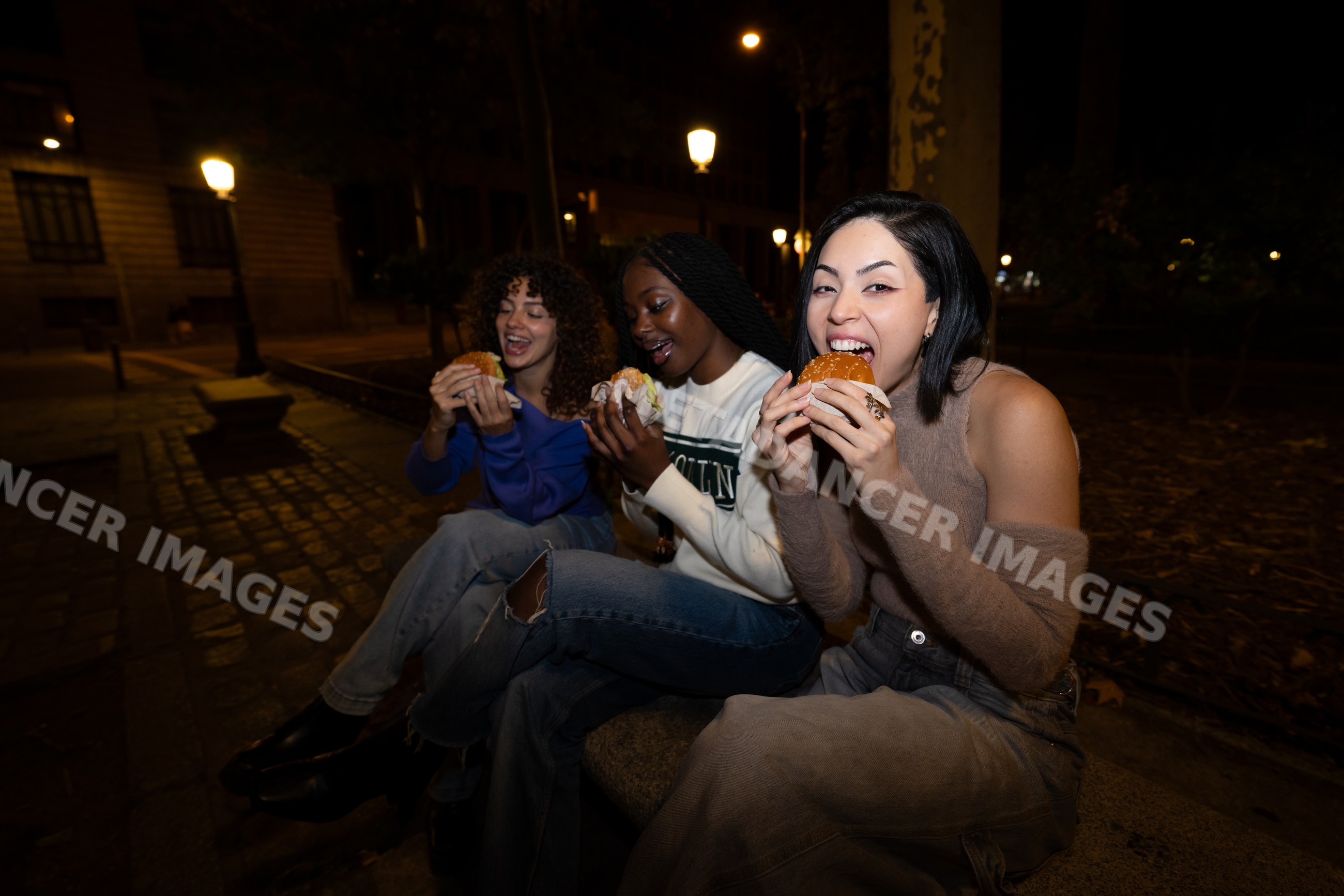 Hispanic, white and Black women enjoying burgers together