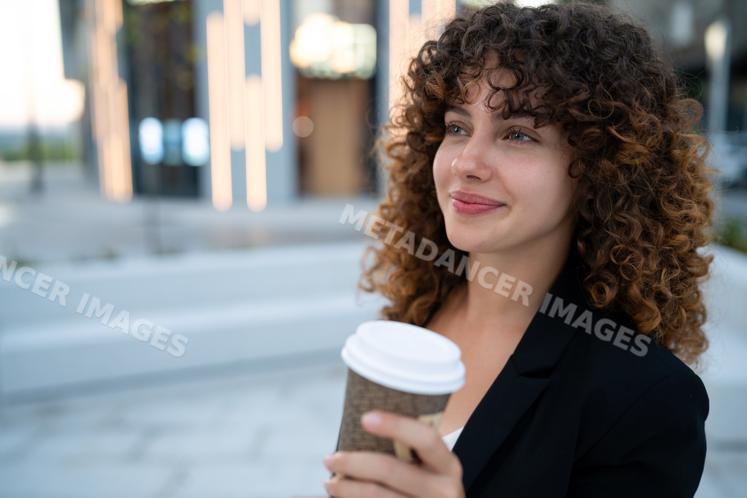 Young white woman holding coffee cup outdoors