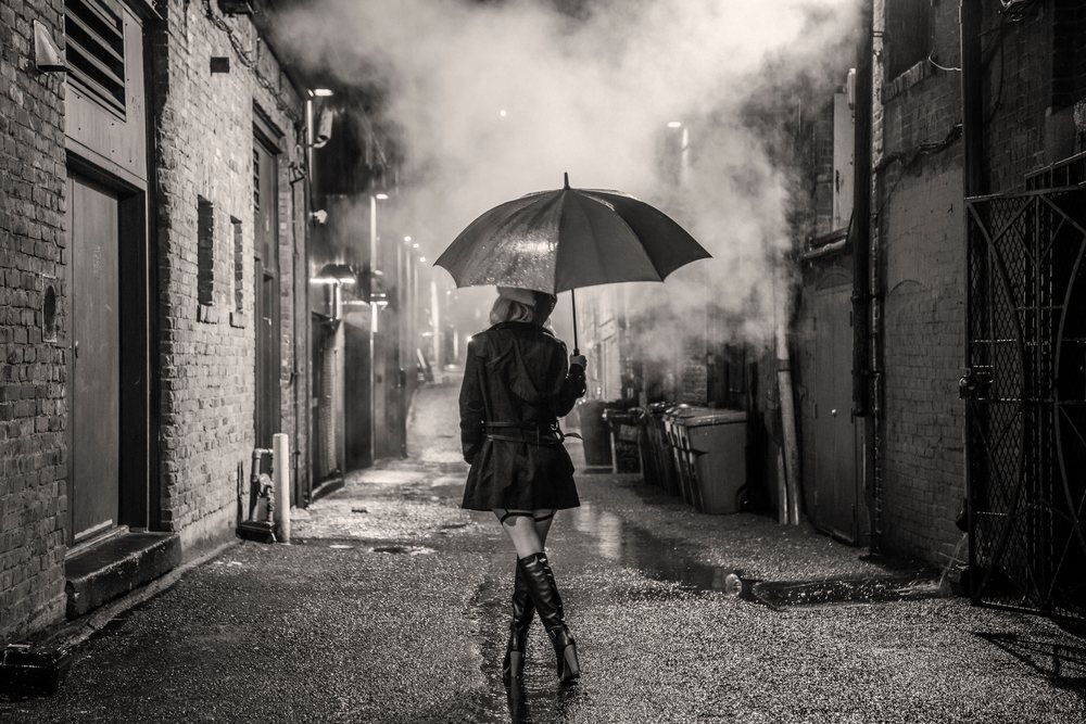 White woman walking under umbrella