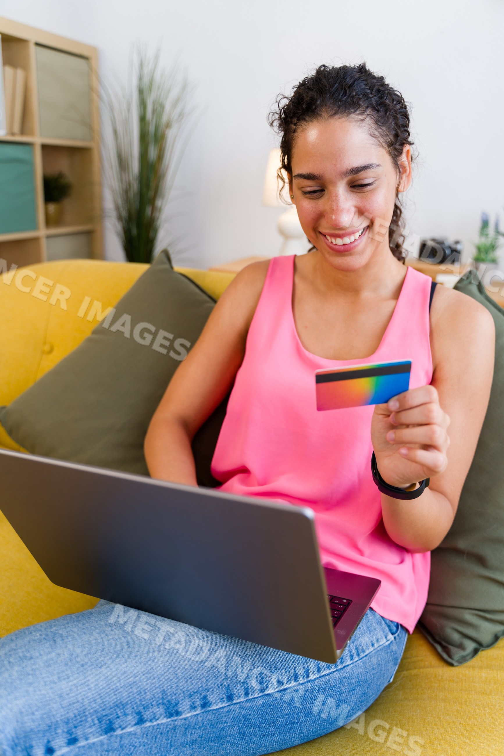 A Hispanic woman holds a payment card