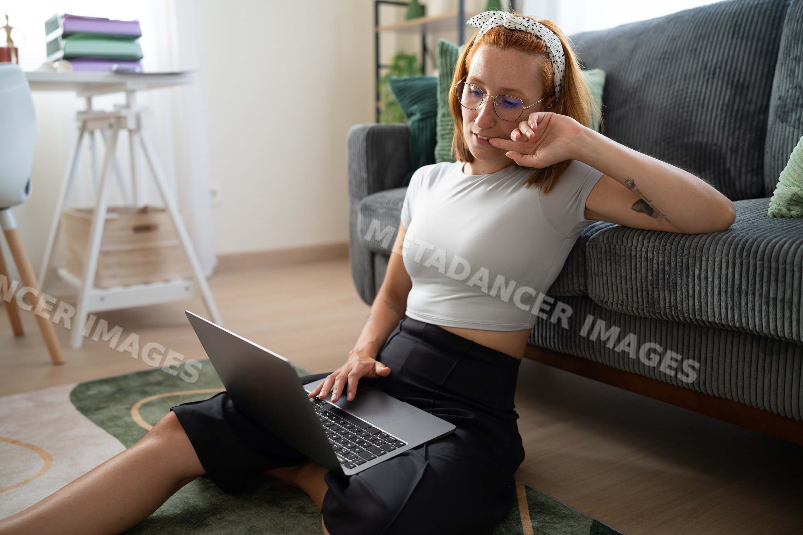 White Woman sitting on floor working on laptop