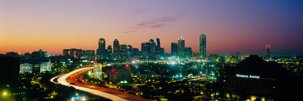 City skyline of dallas, texas at sunset with illuminated buildings