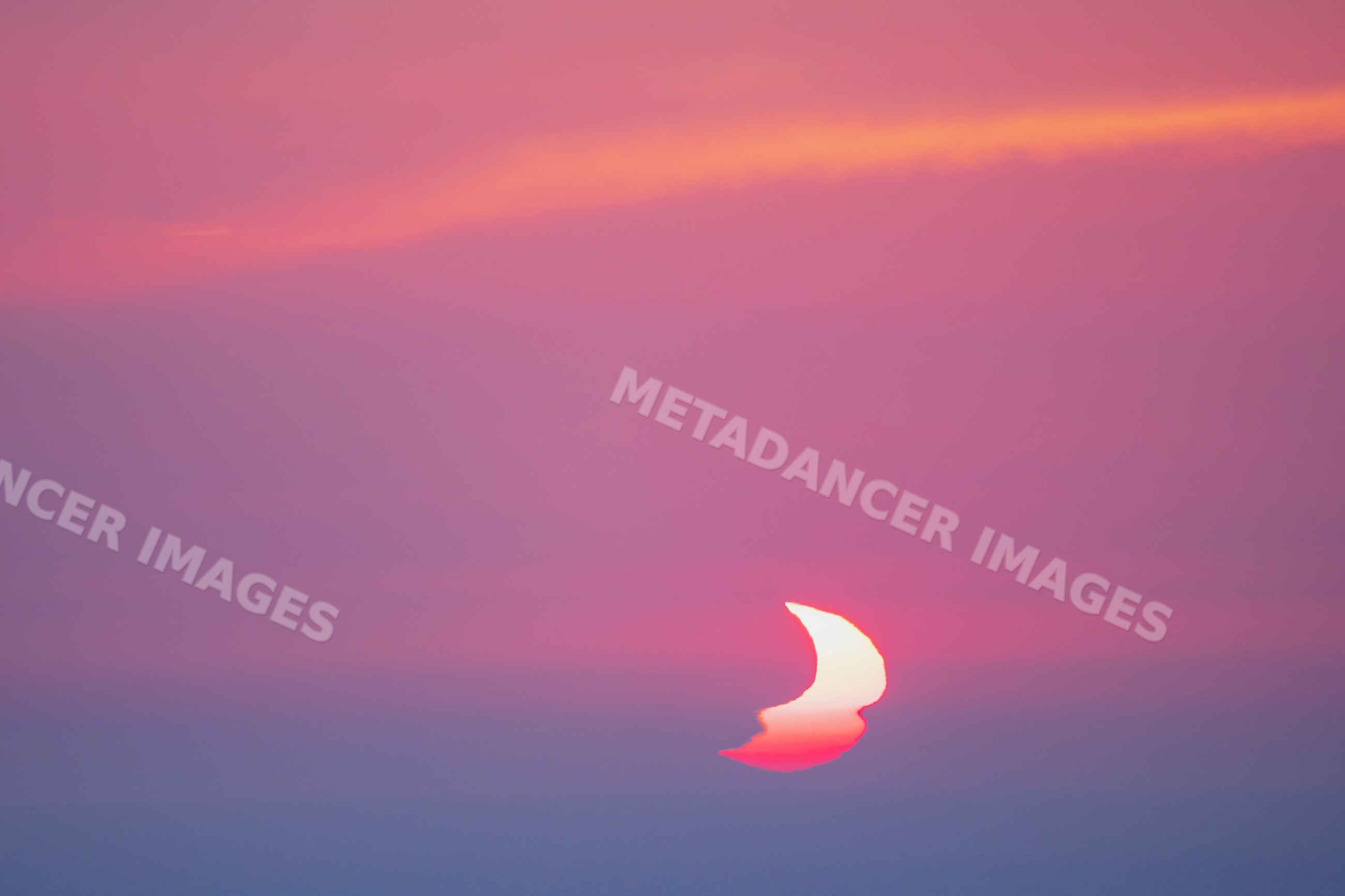 Sunset with partially eclipsed Sun over valldemossa, Mallorca, Spain