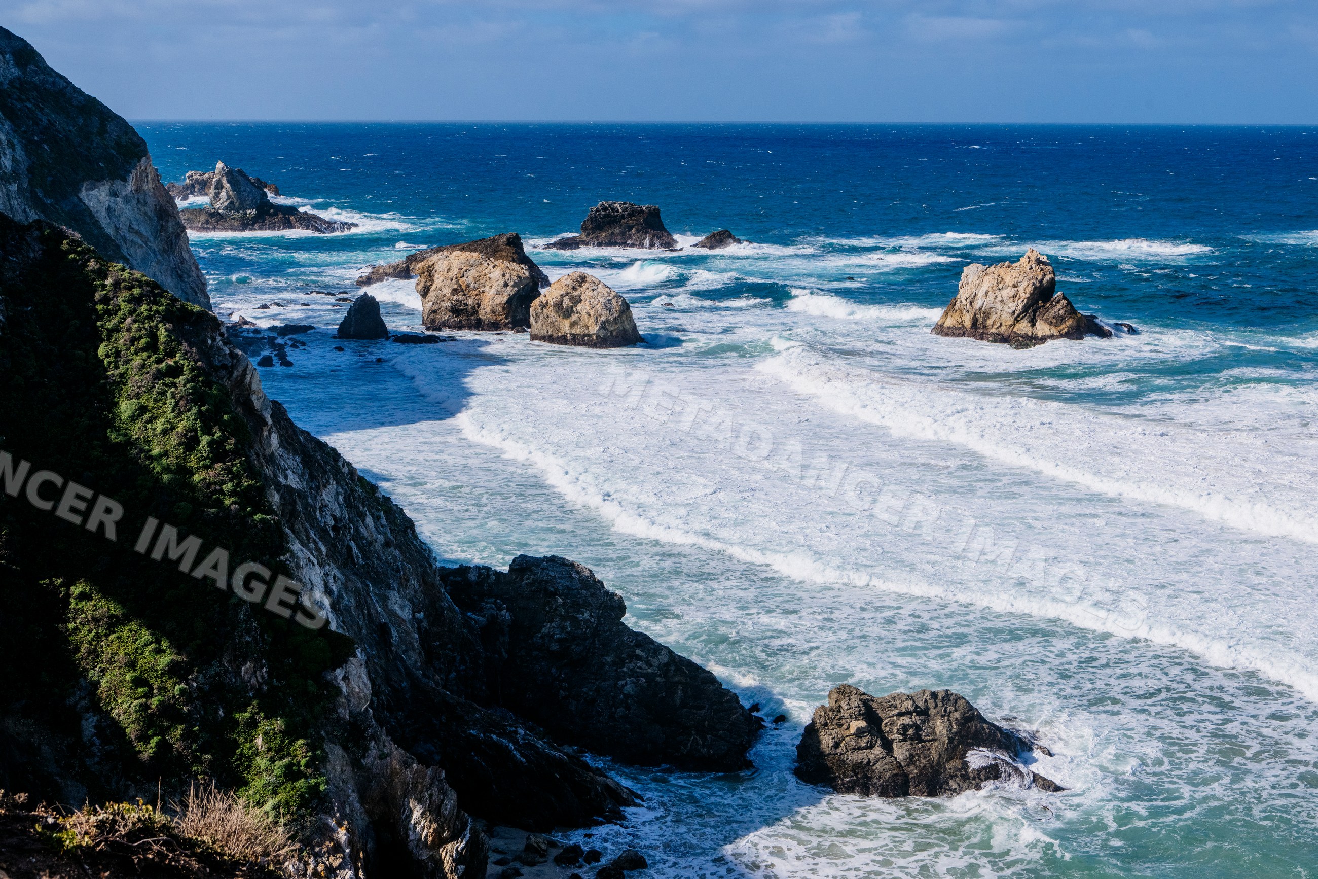 Rocky coastline with ocean waves along California coast