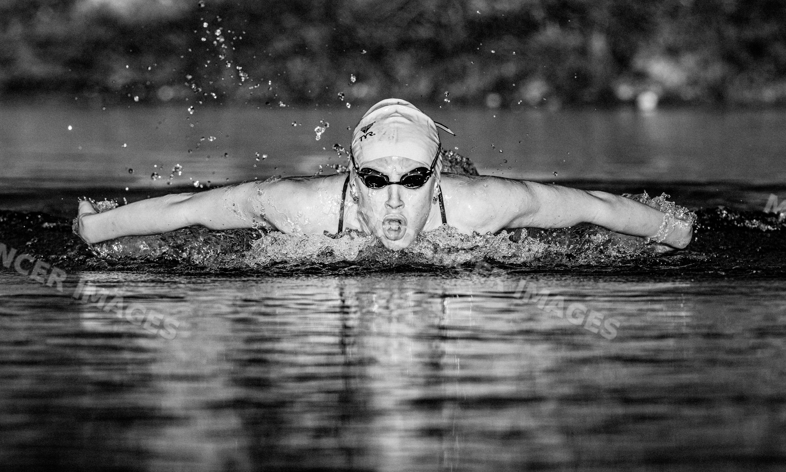 White swimmer performing butterfly stroke with water splashes