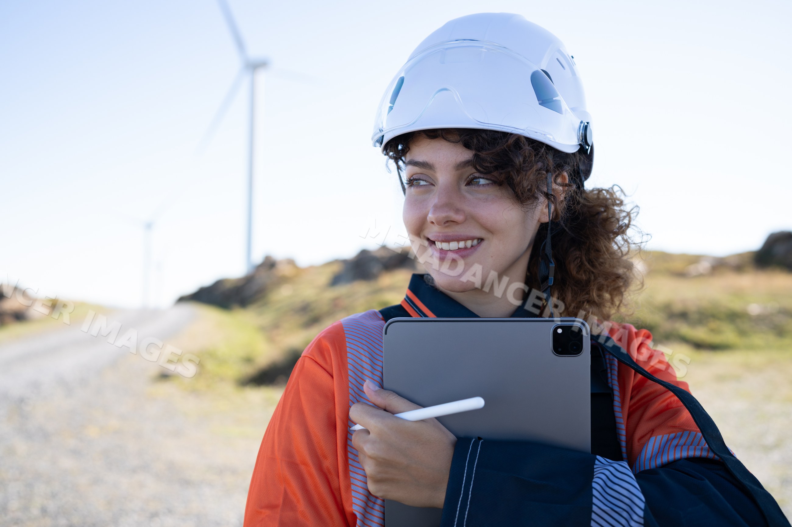 White woman engineer working with a tablet at a wind farm in Galicia