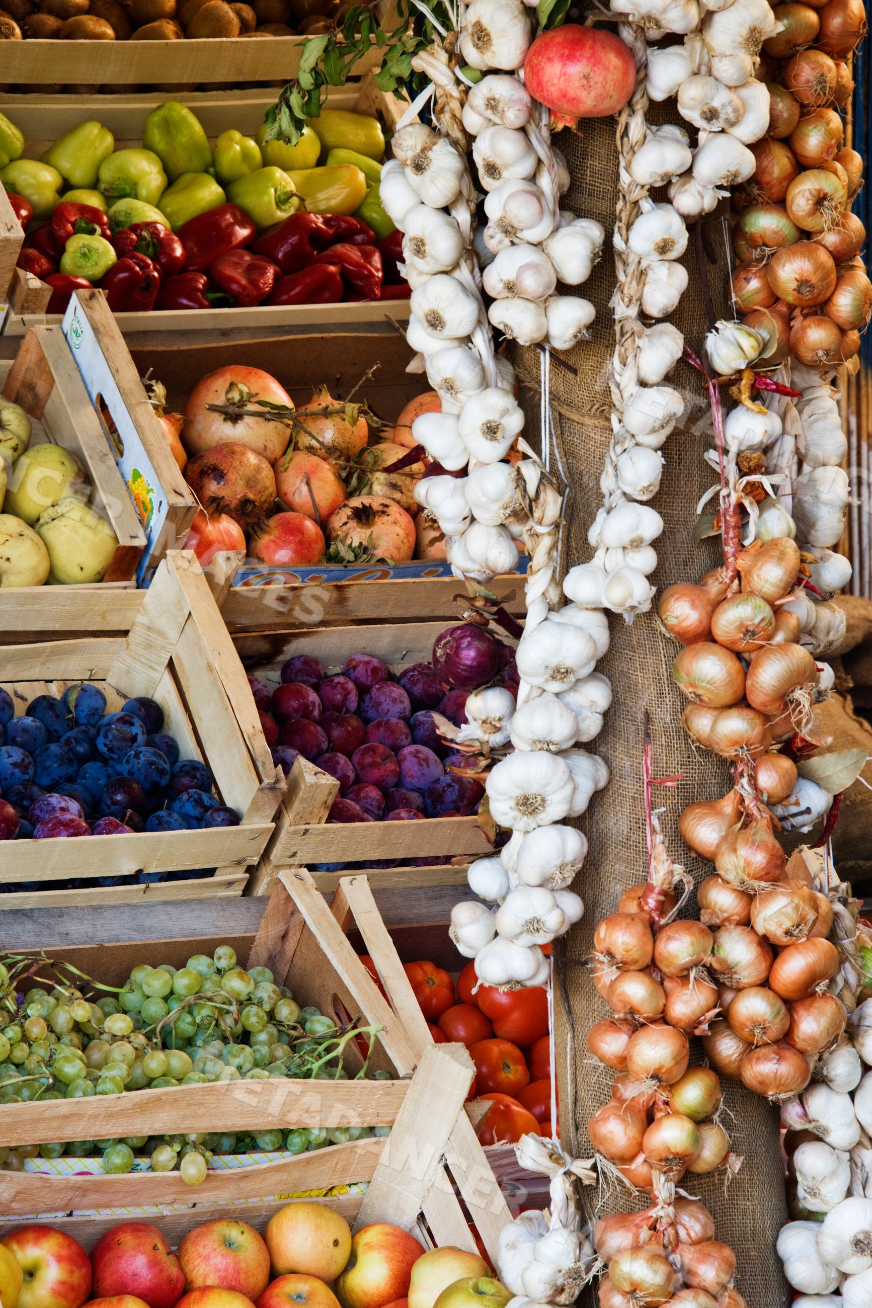Fruit stand with fresh garlic and assorted fruits and vegetables