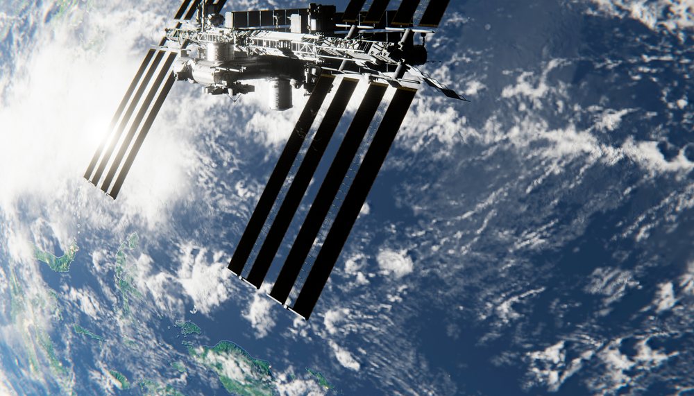 An orbital space station orbits earth with solar panels extended