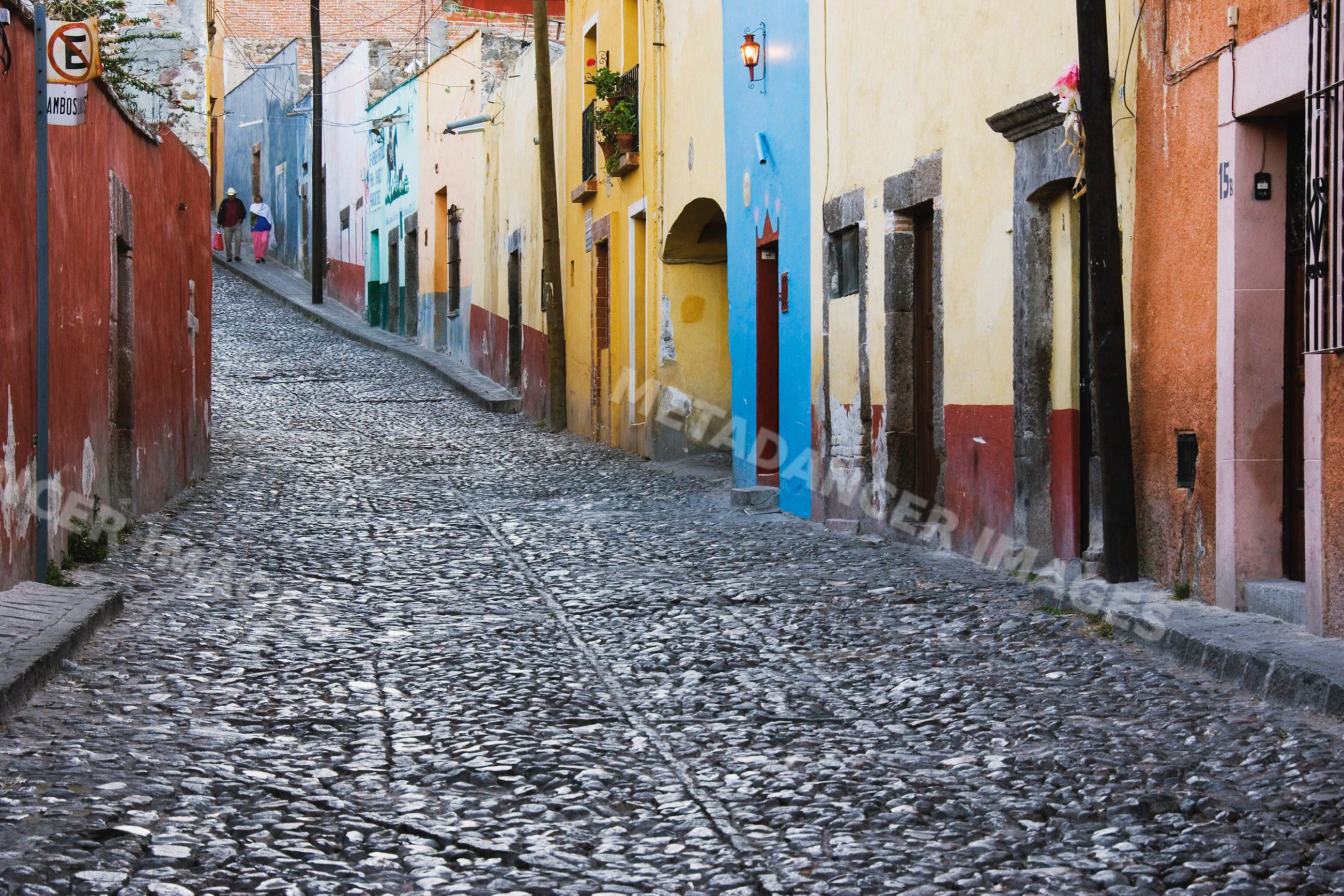 Colorful cobblestone street with pedestrians, mexico