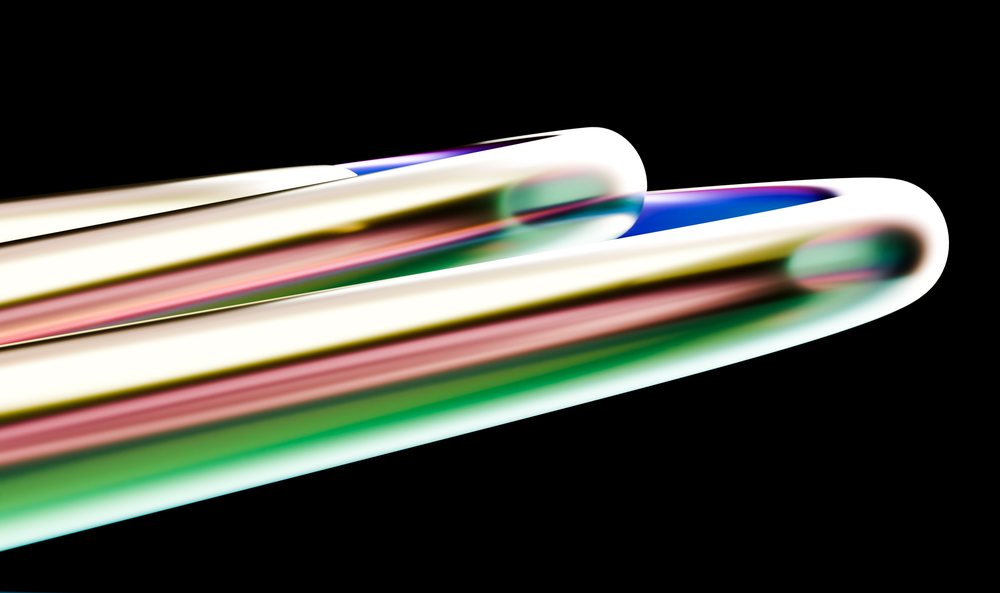 Colorful smooth glass tubes with vibrant reflections isolated