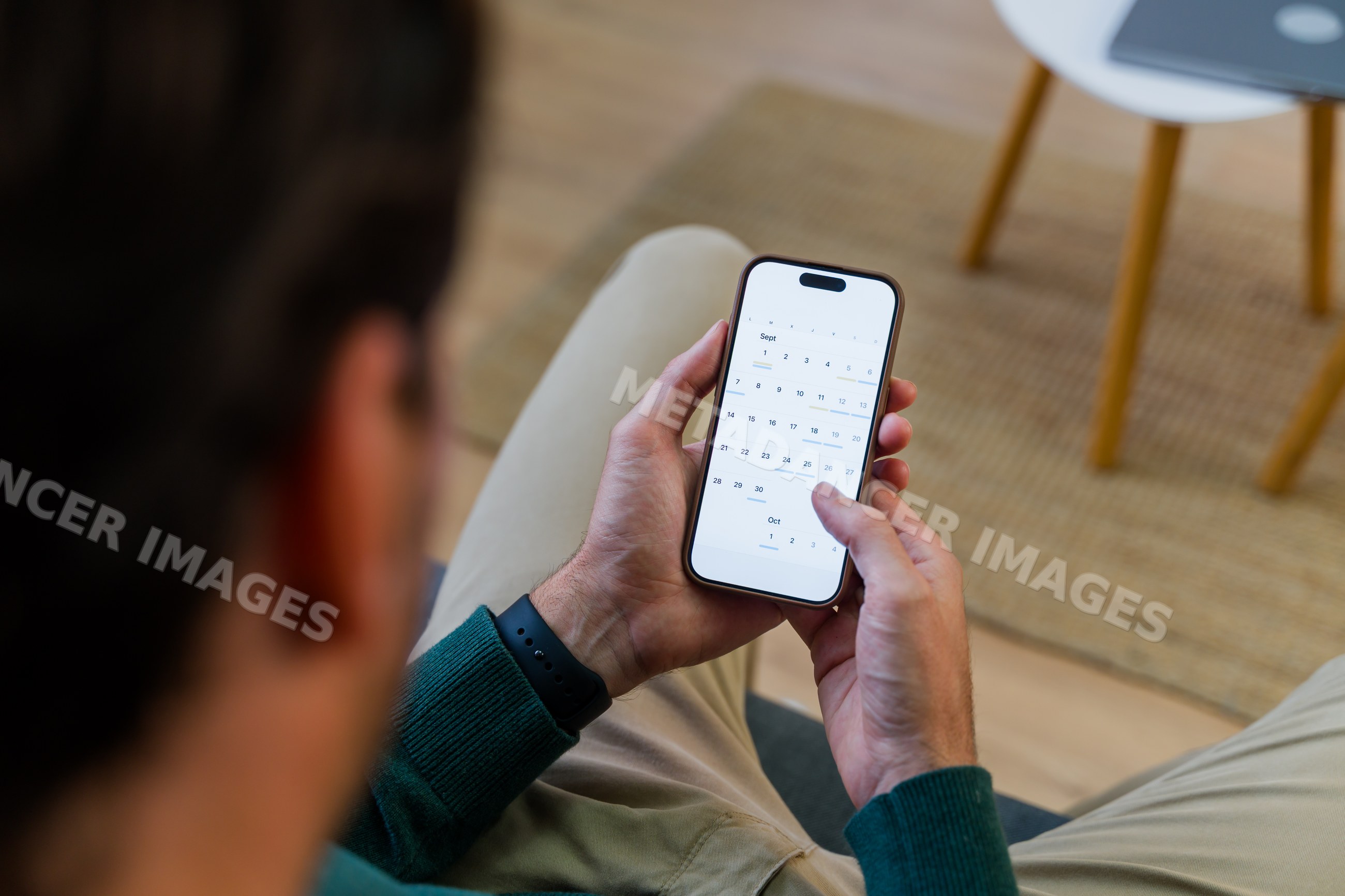 White man using smartphone calendar app for scheduling indoors
