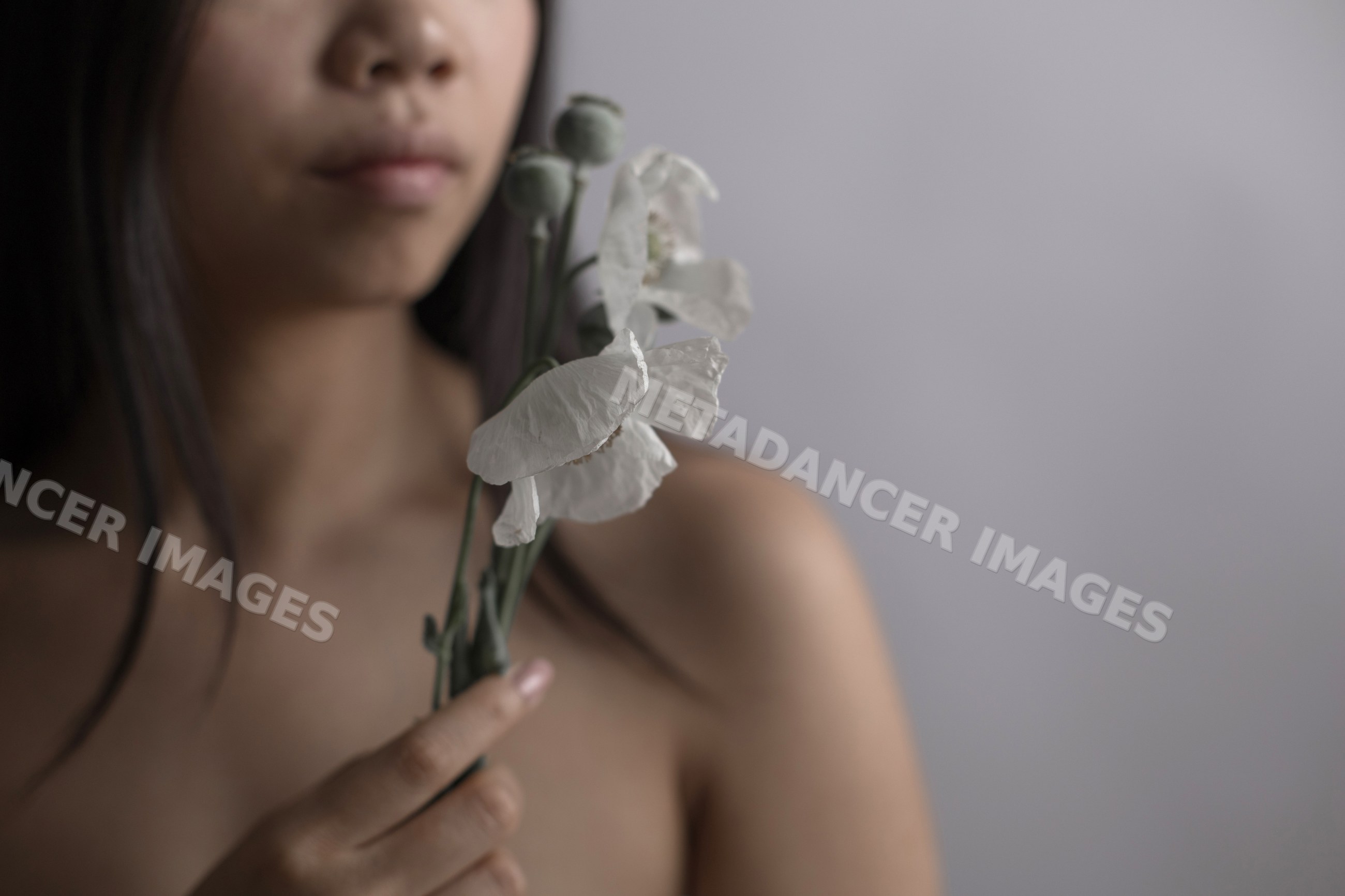 Southeast Asian woman holding white flower in intimate portrait