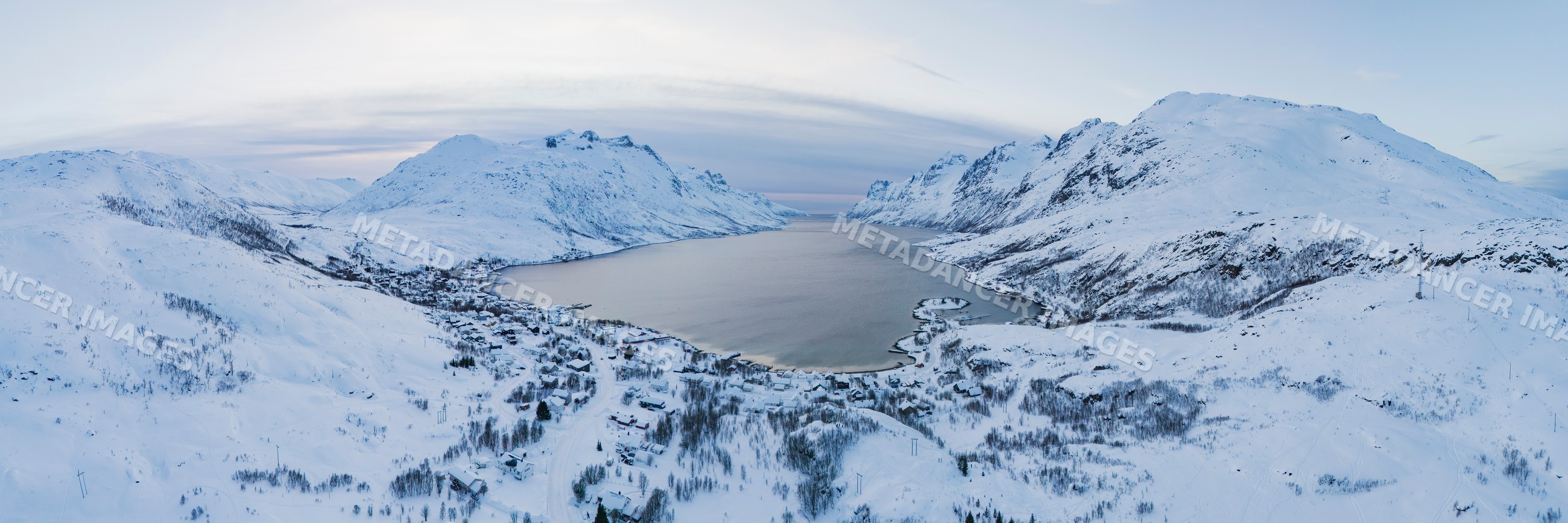 View of ersfjorden fjord sunset with snowy mountains and village